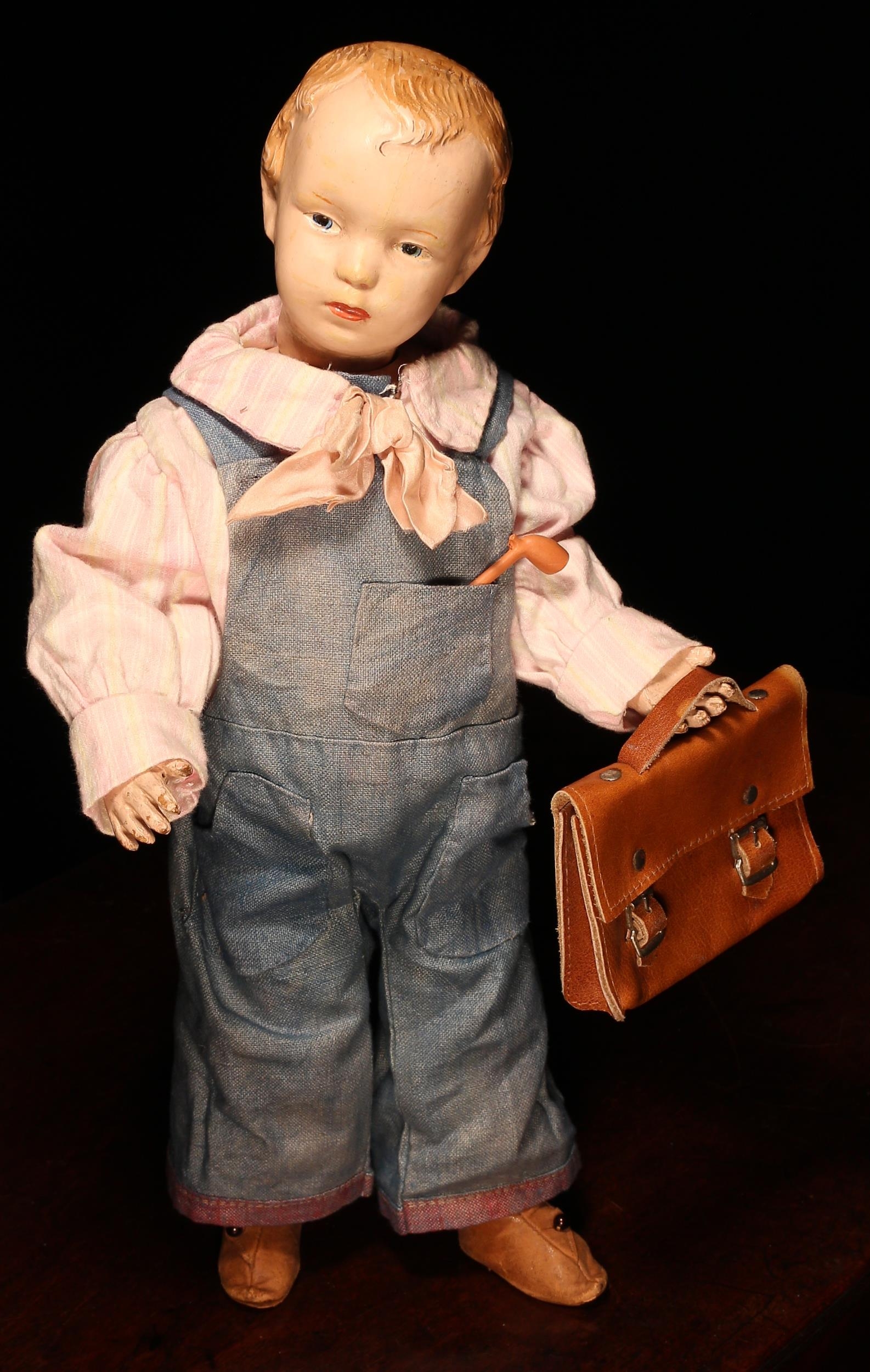 An early 20th century Schoenhut carved and painted wooden character doll, the carved and painted wooden head with painted features including blue intaglio eyes, red lips and blonde hair, painted wooden body, impressed marks, 41cm high