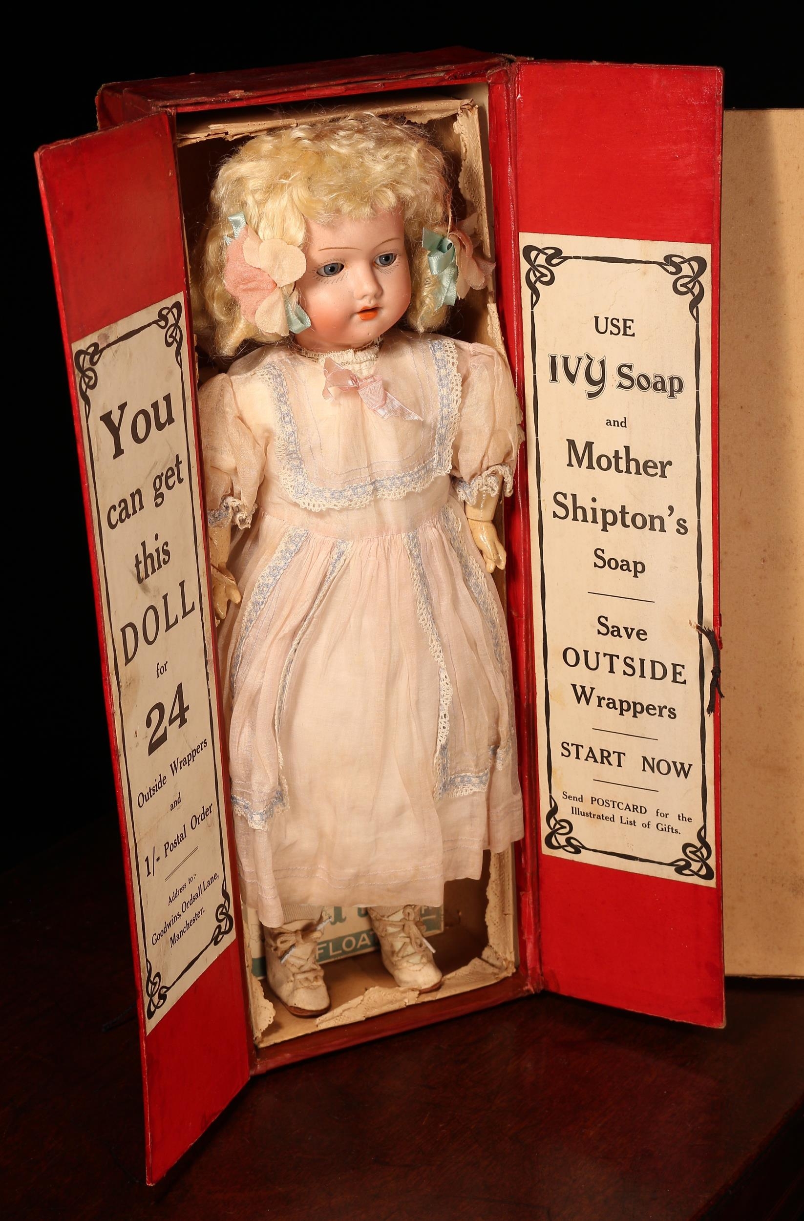 Advertising & Social History Interest - a rare Hermann Steiner (Germany) bisque head and painted composition bodied doll, the bisque head with weighted sleeping blue glass eyes, painted features including brown eyebrows and fine eyelashes, open mouth revealing upper teeth, blonde wig on pate, impressed marks '128, HS, HERM STEINER, 3, GERMANY', 43cm high, presented in an original cardboard shop display/counter promotional cardboard box, the interior with printed labels 'YOU CAN GET THIS DOLL FOR 24 OUTSIDE WRAPPERS AND 1/- POSTAL ORDER, ADDRESS TO:- GOODWINS, ORDSALL LANE, MANCHESTER.' and 'USE IVY SOAP AND MOTHER SHIPTON'S SOAP, SAVE OUTSIDE WRAPPERS, START NOW, SEND POSTCARD FOR ILLUSTRATED LIST OF GIFTS.', together with an unused bar of Ivy soap in original wrapper