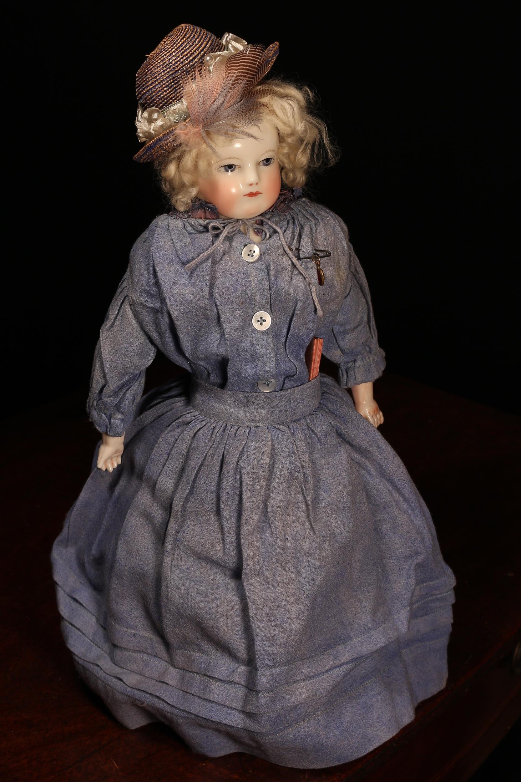 A 19th century glazed china shoulder head doll, attributed to Maison Huret (France), the glazed head with painted features including fine feathered brown eyebrows, fine eyelashes, blue eyes, red lips and blush red cheeks, blonde wig, white kid leather body with bisque lower arms, 36cm high