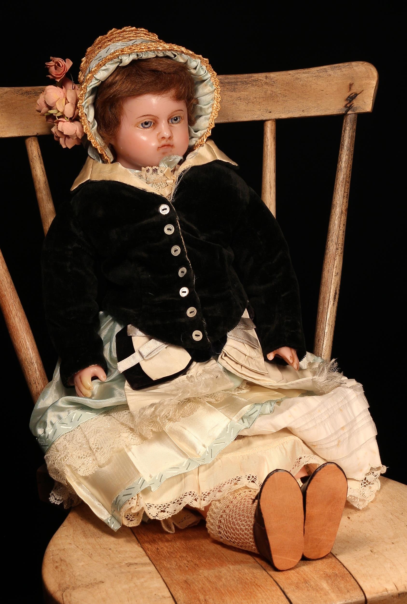 A late 19th century poured wax shoulder head doll, unmarked but attributed to Pierotti, the slightly turned poured wax shoulder head inset with fixed blue glass eyes, inserted eyebrows, brown inserted hair, partially stuffed cloth body with wax limbs, 51cm high