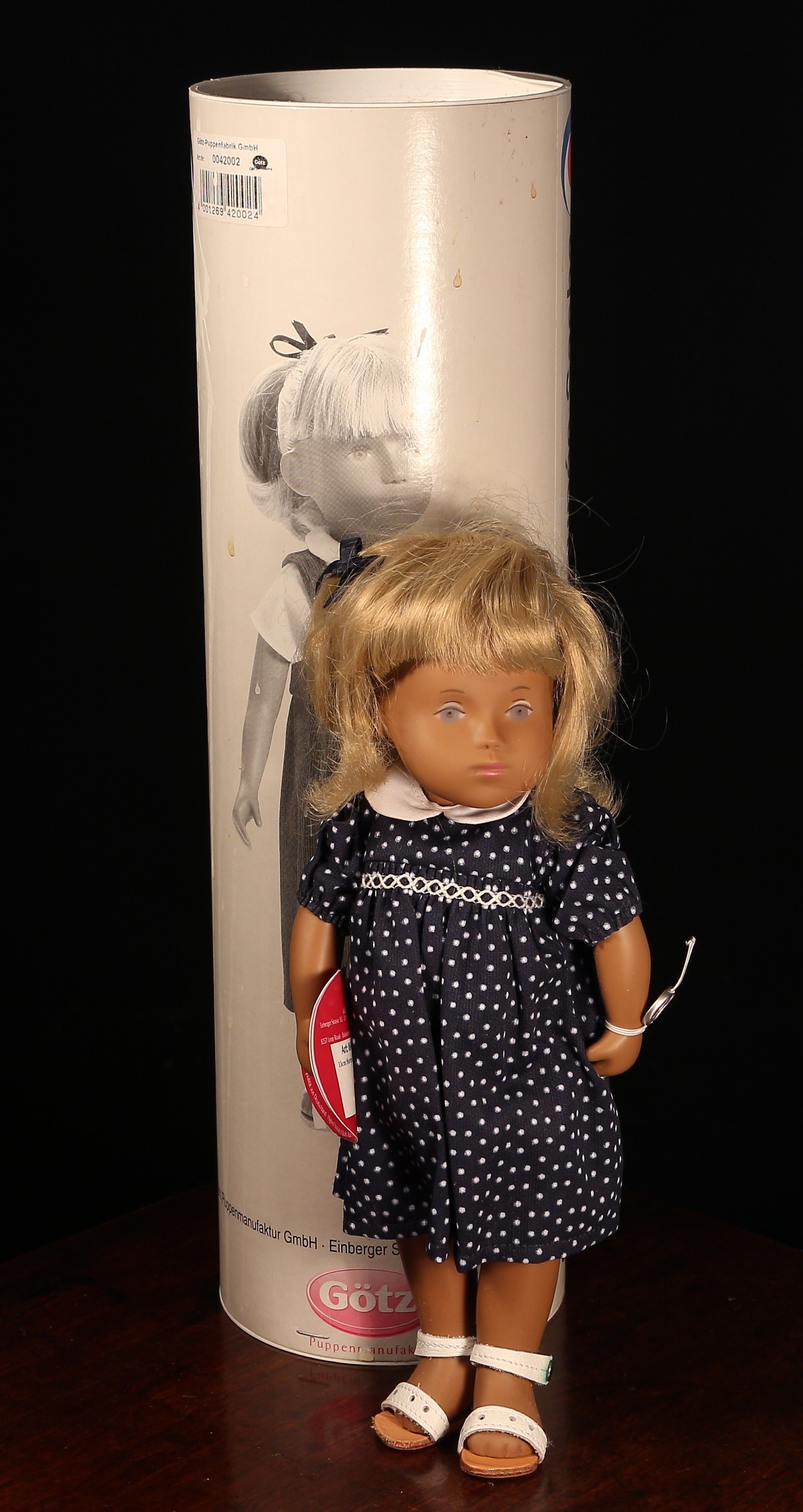 A Götz Sasha Morgenthaler 00 42002 Esther blonde doll, wearing a blue dress with white collar and white polka dot print, matching knickers, white undershirt and white sandals, trademark tag to wrist and tags, 33cm high, boxed - cardboard tube