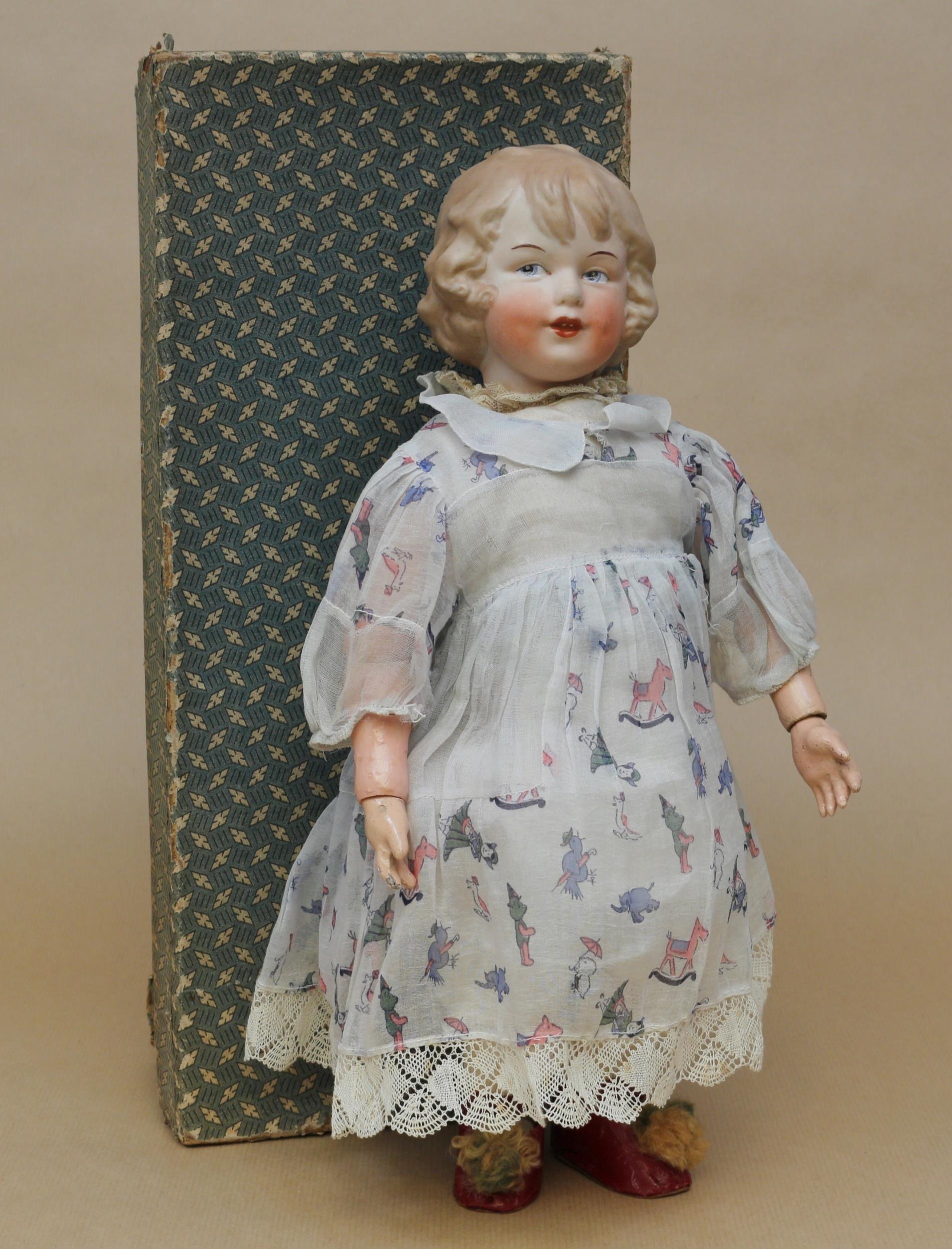 A Gebrüder Heubach (Germany) bisque head and painted part ball jointed composition bodied character doll, the bisque head with painted features including side glancing blue intaglio eyes and brown eyebrows, moulded and painted hair, impressed marks '7956 [HEUBACH] GERMANY', 39cm high, square paper label to the reverse of the torso, displayed in an unmarked rectangular cardboard box with lid