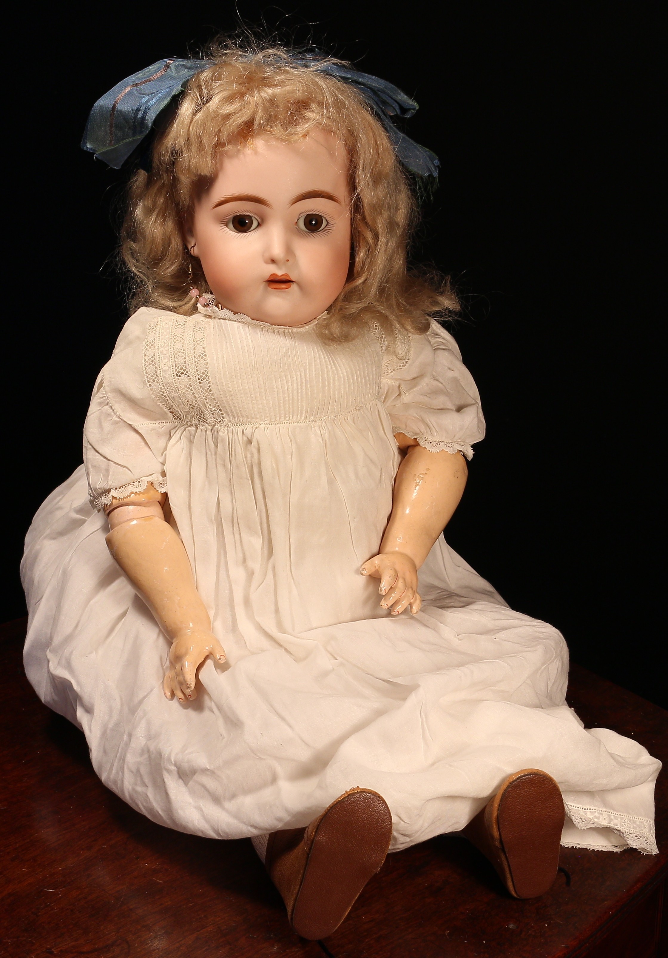 A Kämmer & Reinhardt (Germany) bisque head and ball jointed painted composition bodied doll, the bisque head with weighted sleeping brown glass eyes, painted features including feathered brown eyebrows and fine eyelashes, open mouth revealing upper teeth, pierced ears, blonde wig on pate, impressed marks '192, 11', 52cm high
