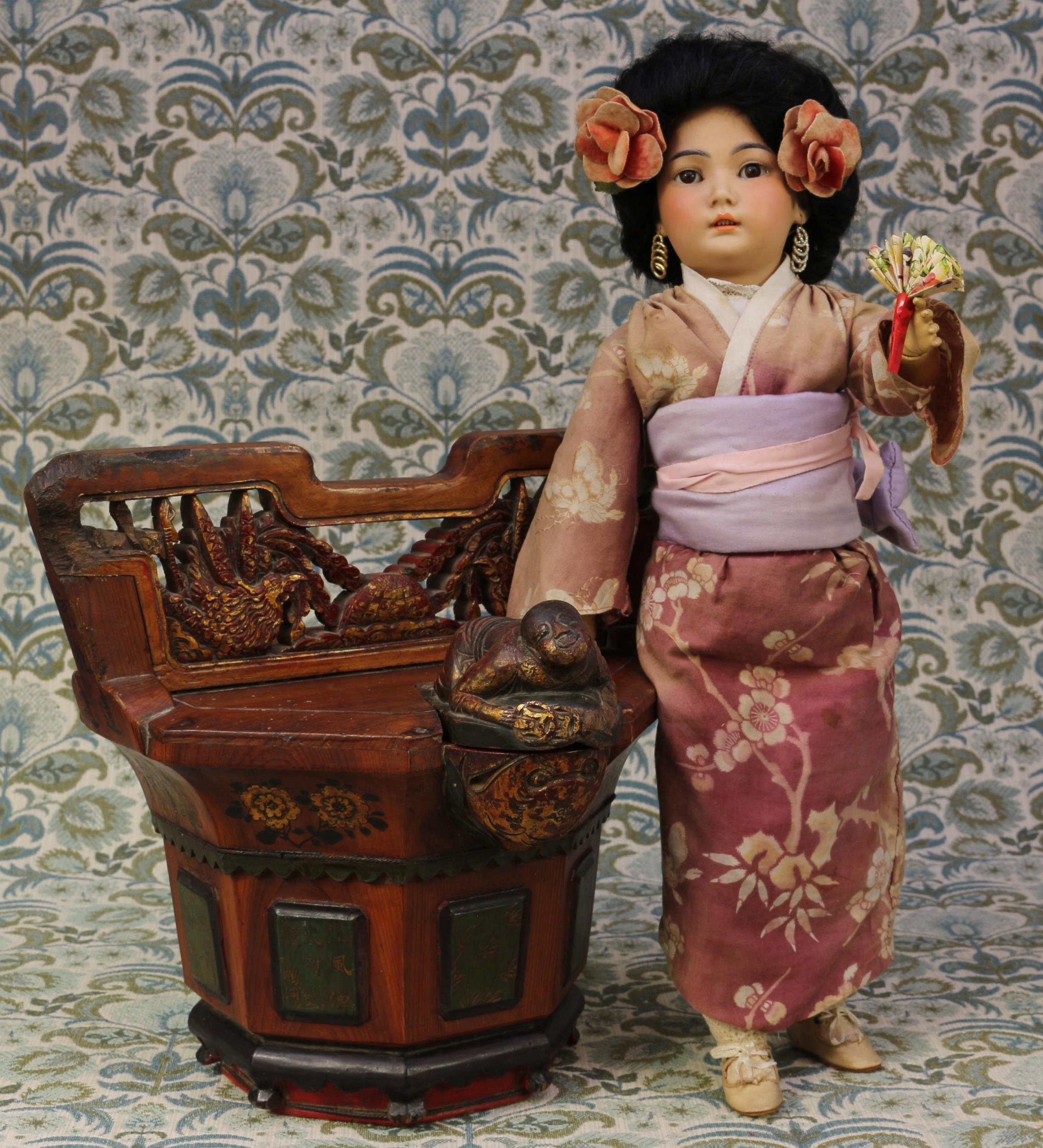 A Simon & Halbig (Germany) bisque head and painted ball jointed composition bodied Oriental doll, the bisque head with weighted sleeping brown glass eyes, painted features including black feathered eyebrows, fine eyelashes and open mouth revealing teeth, black wig on pate, pierced ears, impressed marks 'SIMON & HALBIG, GERMANY, 1329, 7', 51cm high