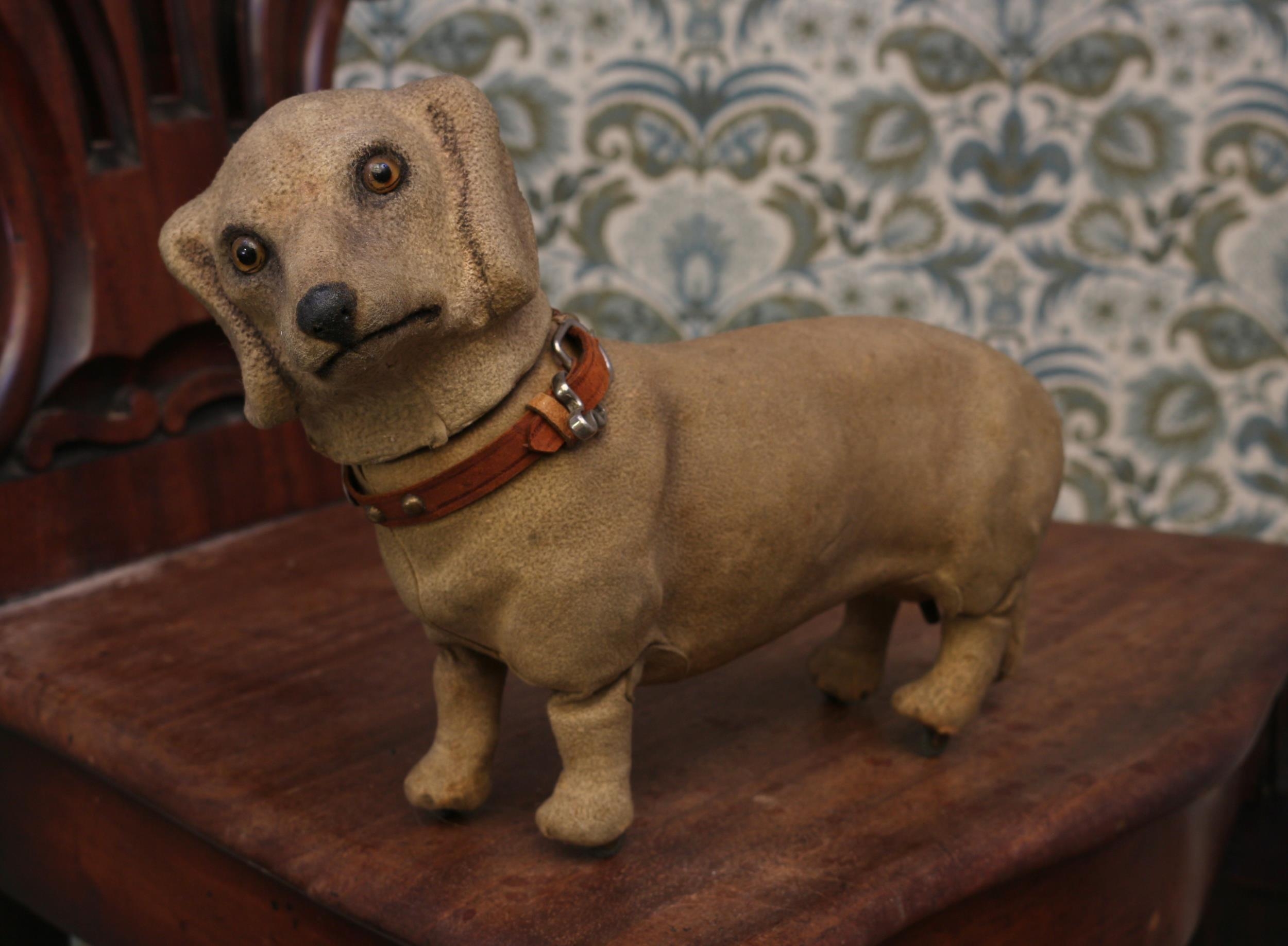 A late 19th century/early 20th century novelty clockwork automaton toy, in the form of a Dachshund, by Roullet & Decamps (France), amber and black glass eyes, the papier-mâché body covered in cream 'suede' type material, brown leather collar, 27cm long with key