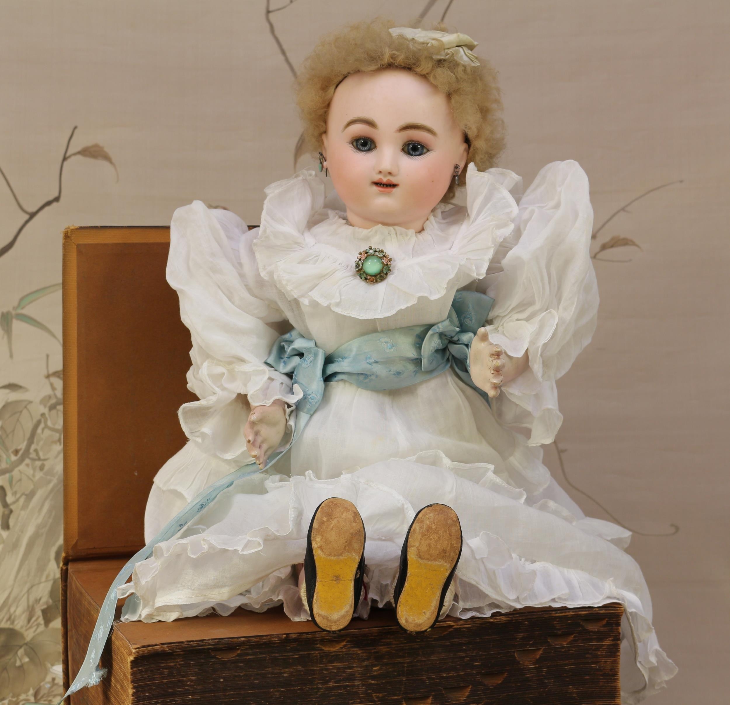 A Jules Nicholas Steiner (France) bisque head Bébé Parlant Automatique Gigoteur doll, fixed blue glass eyes, painted features including brown feathered eyebrows and fine eyelashes, open mouth revealing teeth, blonde wig on pate, pierced ears, unmarked head, Tauflinge type body with painted composition arms and lower legs, fabric torso with kid leather upper legs, fixed key wind mechanism with lever, 58cm high