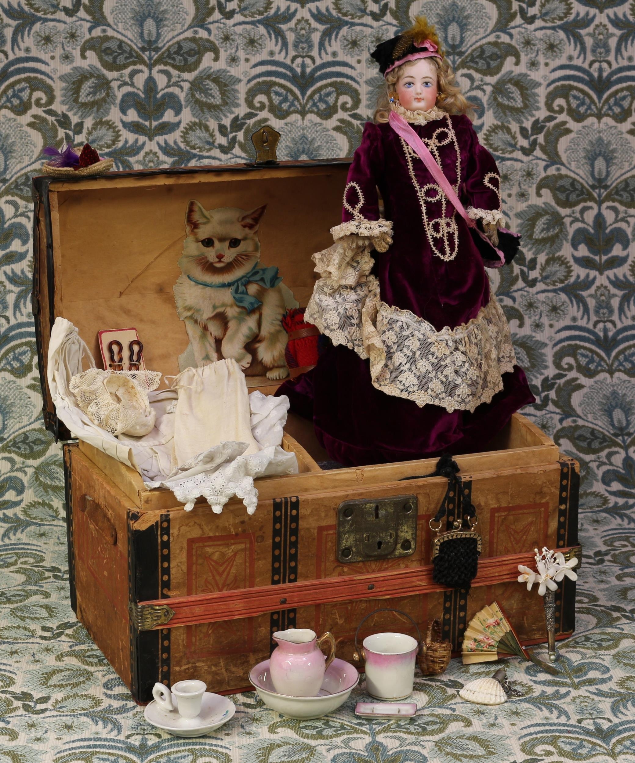 A late 19th century Francois Gaultier pale bisque head French Poupée de Mode or fashion doll, the pale bisque shoulder head with painted features including brown feathered eyebrows, fine eyelashes, blue eyes and red lips, pierced ears, blonde wig, impressed marks 'F o G', kid leather body, 35.5cm high; together with a paper covered domed top trunk, of small proportions, 22cm high, 36cm wide, 21cm deep, the interior partially fitted with a lift out tray containing various doll accessories and miniatures (quantity)