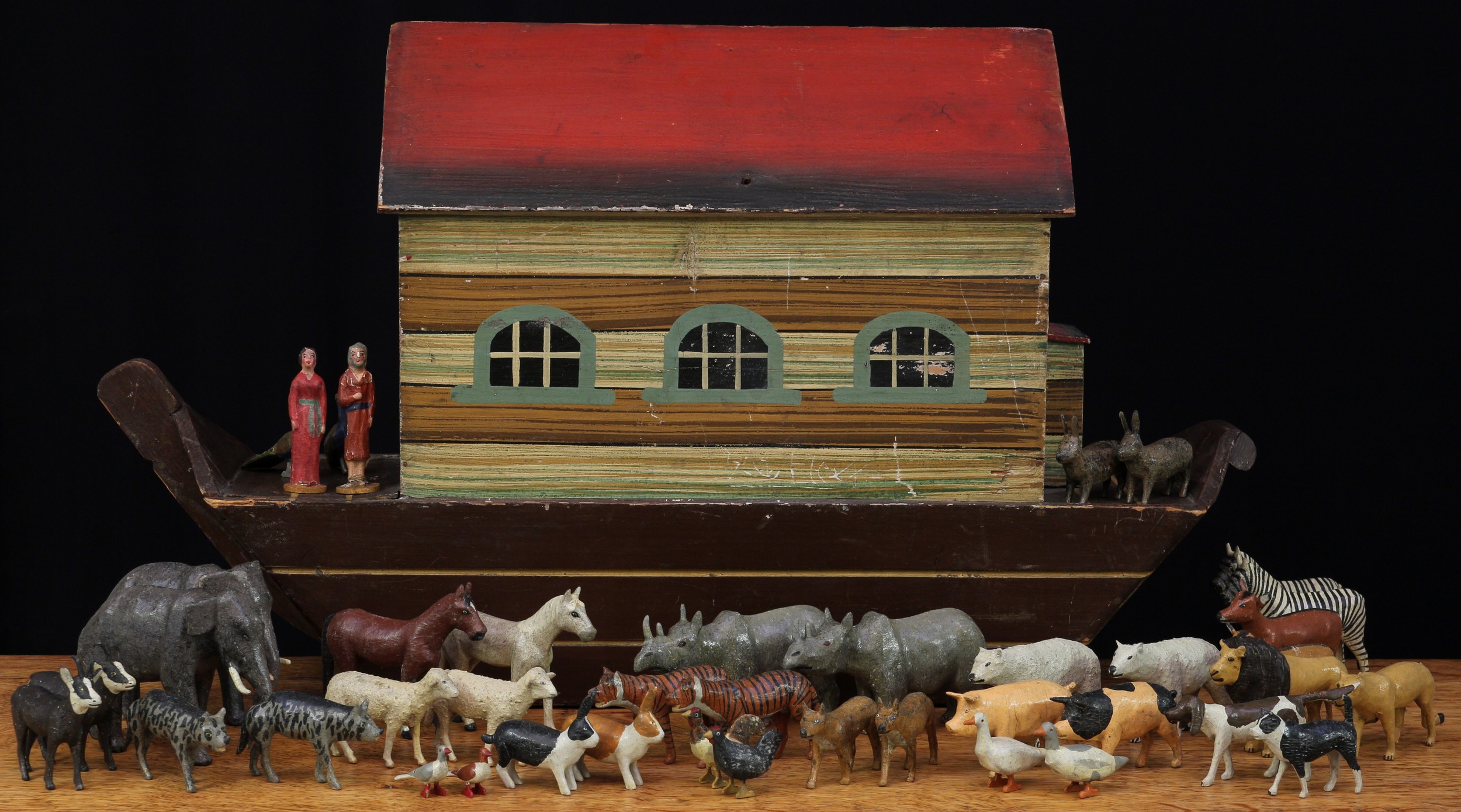 Folk Art & Juvenalia - a 19th century German painted wooden Noah's Ark, hinged cover, with a collection of carved and painted wooden animals and figures en suite including Elephants, Polar Bears, Pigs, Rabbits, Lions, Horses, Rhinos etc, 66cm long, probably produced in the Erziberge Region in Germany (approximately 42 single figures)