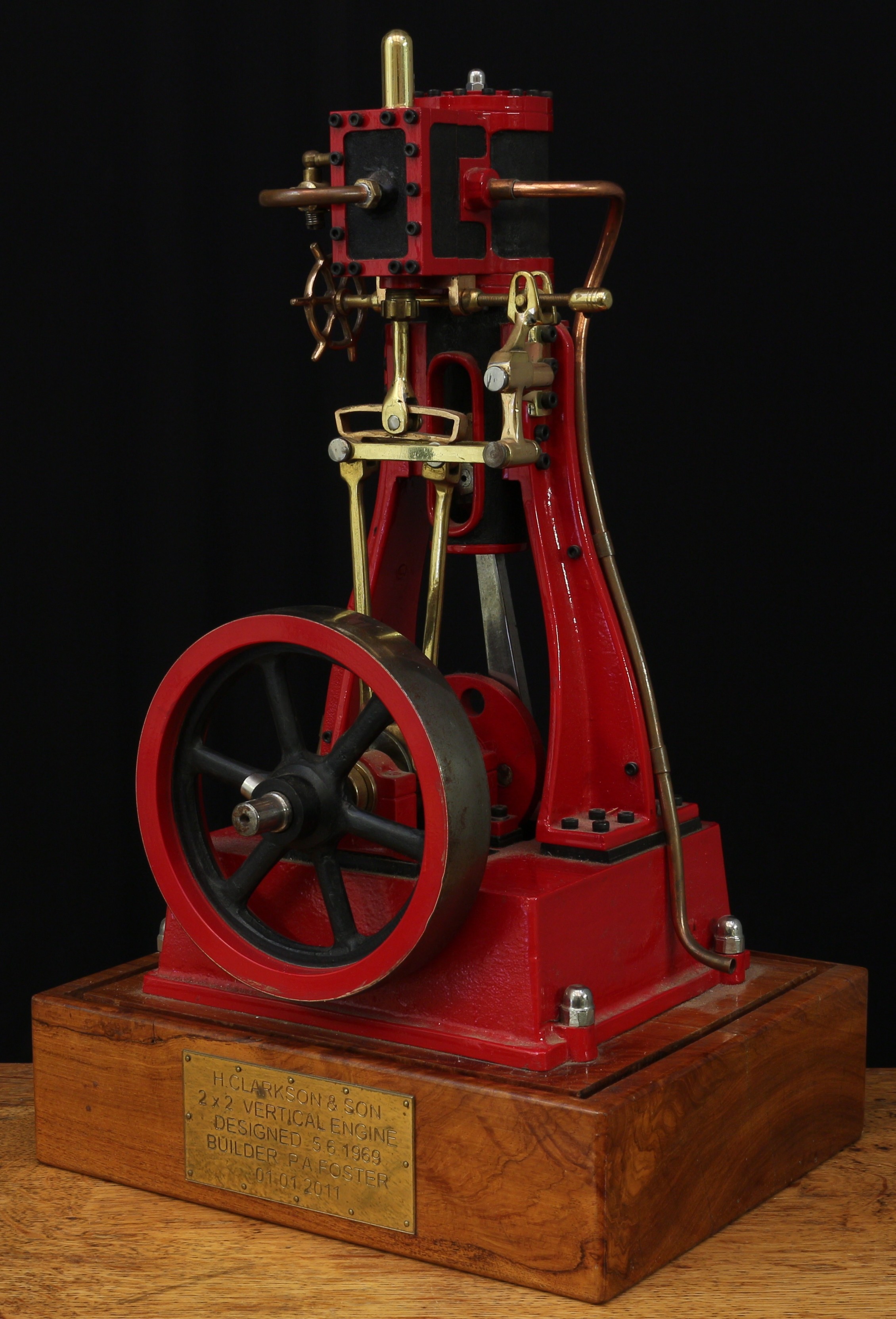 A well-engineered live steam model of a H.Clarkson & Son 2x2 vertical engine, designed on the 5th June, 1969 and built by P.A.Foster on the 1st January 2011, raised upon a rectangular shaped wooden display plinth, 49cm high (measurements including plinth)