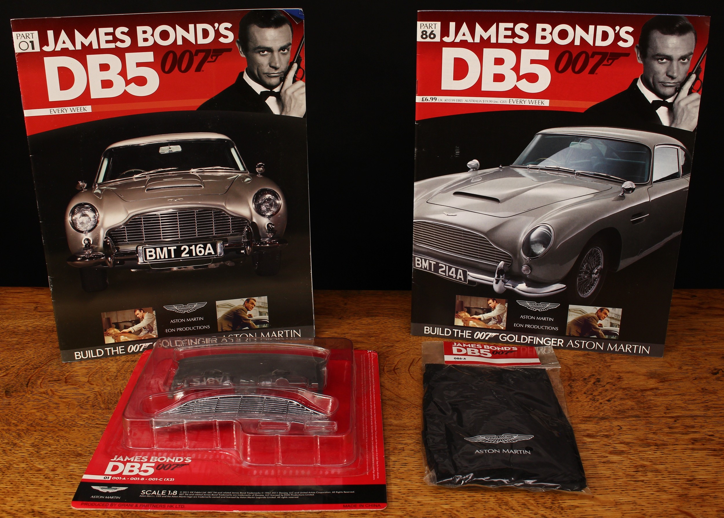An Eaglemoss Publications James Bond 007 1:8 scale diecast Goldfinger Aston Martin DB5 construction set, unbuilt and comprising most periodical magazines and parts in unopened packets (missing parts and supplements comprise of No.41, No.42, No.43, No.46 and No.47), two ring binder folders, three part identification sheets, various literature and gifts including screwdrivers and a screw box