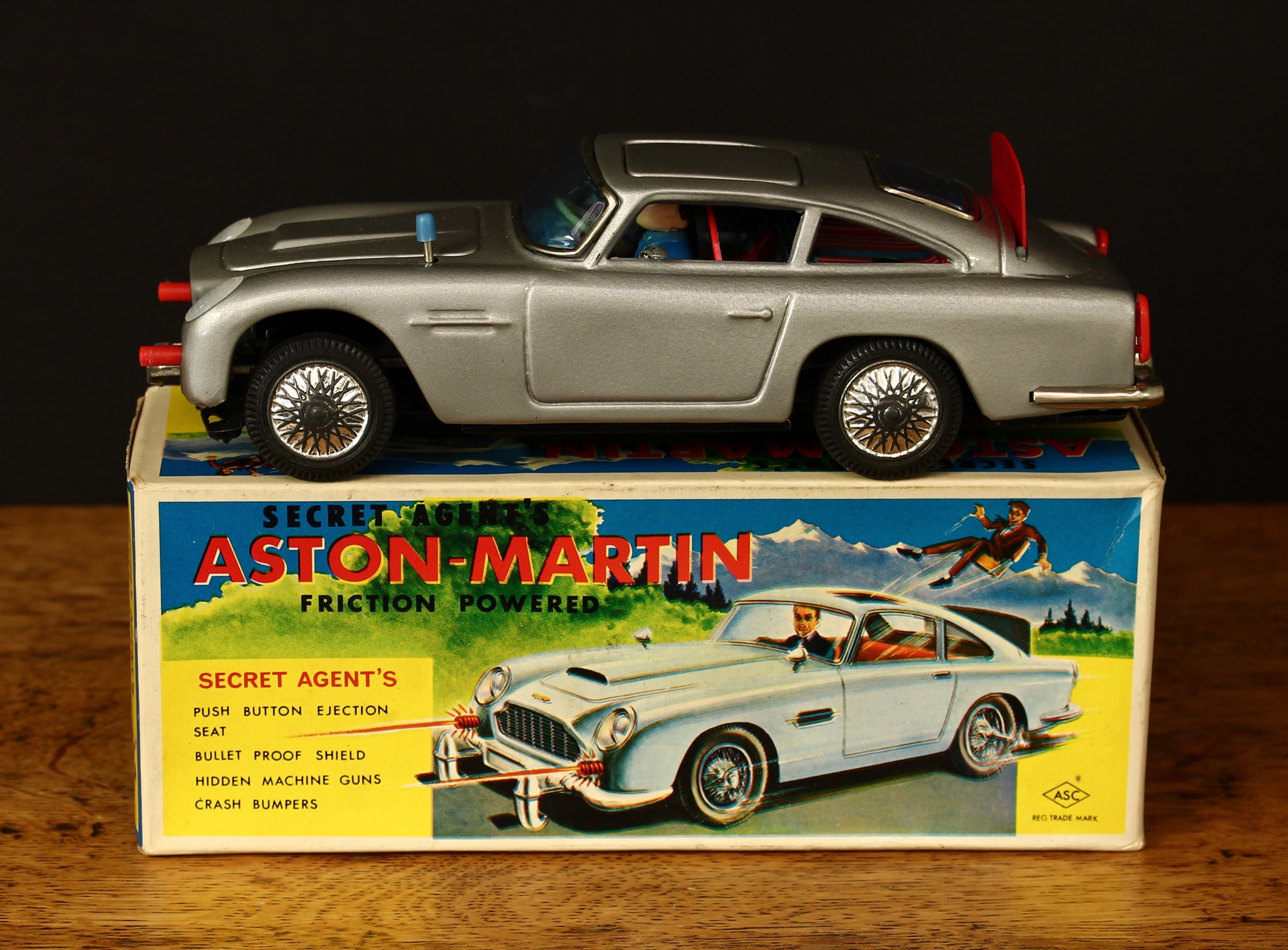 A 1960's ASC (Aoshin, Japan) No.1-230 'James Bond 007' tinplate and  friction driven Aston-Martin, silver body, lithographed detail to interior with seated plastic figures, boxed