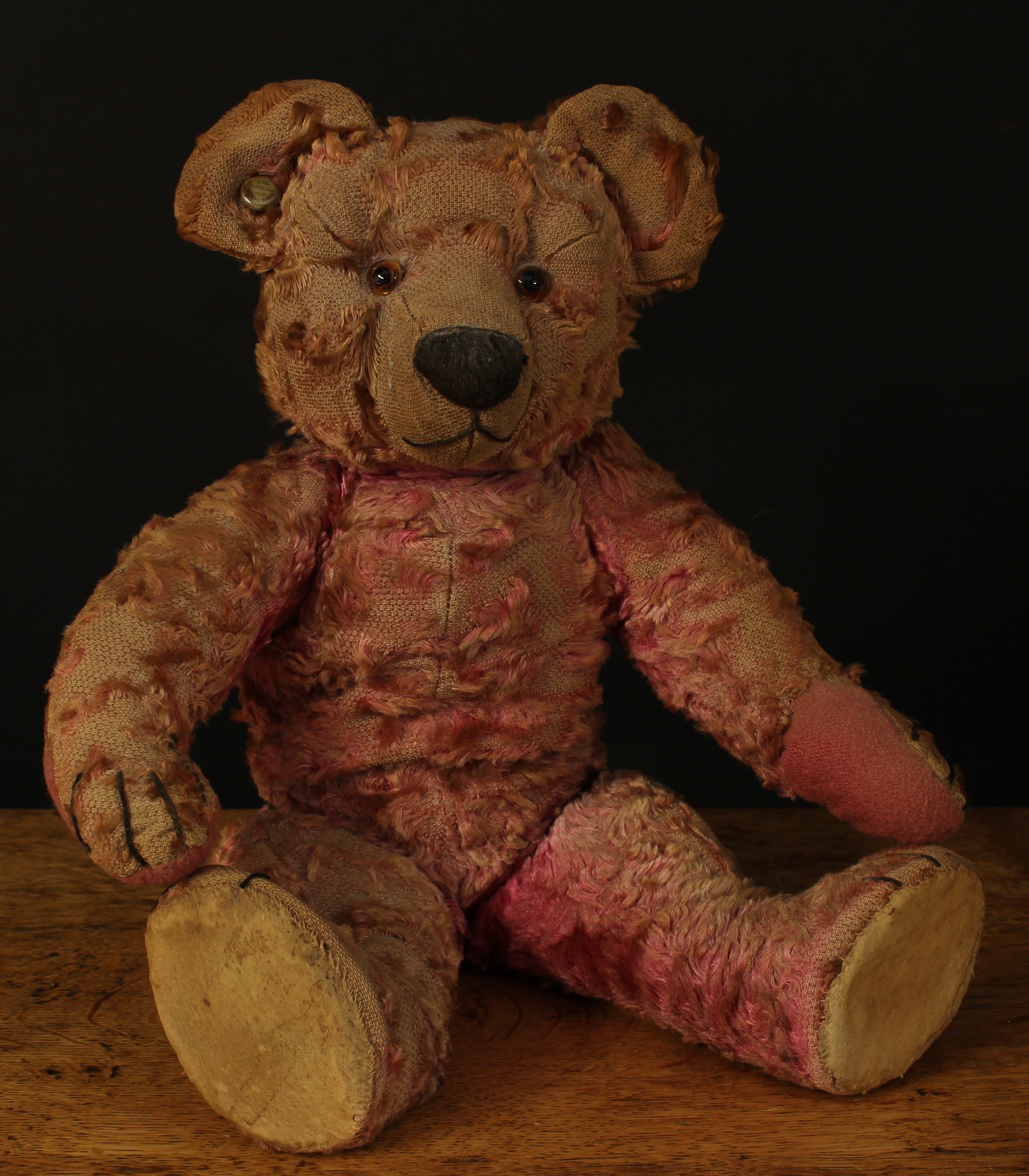 A rare 1930's Chad Valley pink mohair jointed teddy bear, amber and black glass eyes, pronounced snout with vertically brown stitched nose and mouth, later replacement pads to hands and feet with stitched claws/paws, inoperable squeaker to torso, trademark 'CHAD VALLEY, BRITISH HYGIENIC TOYS' button to ear, 40cm high