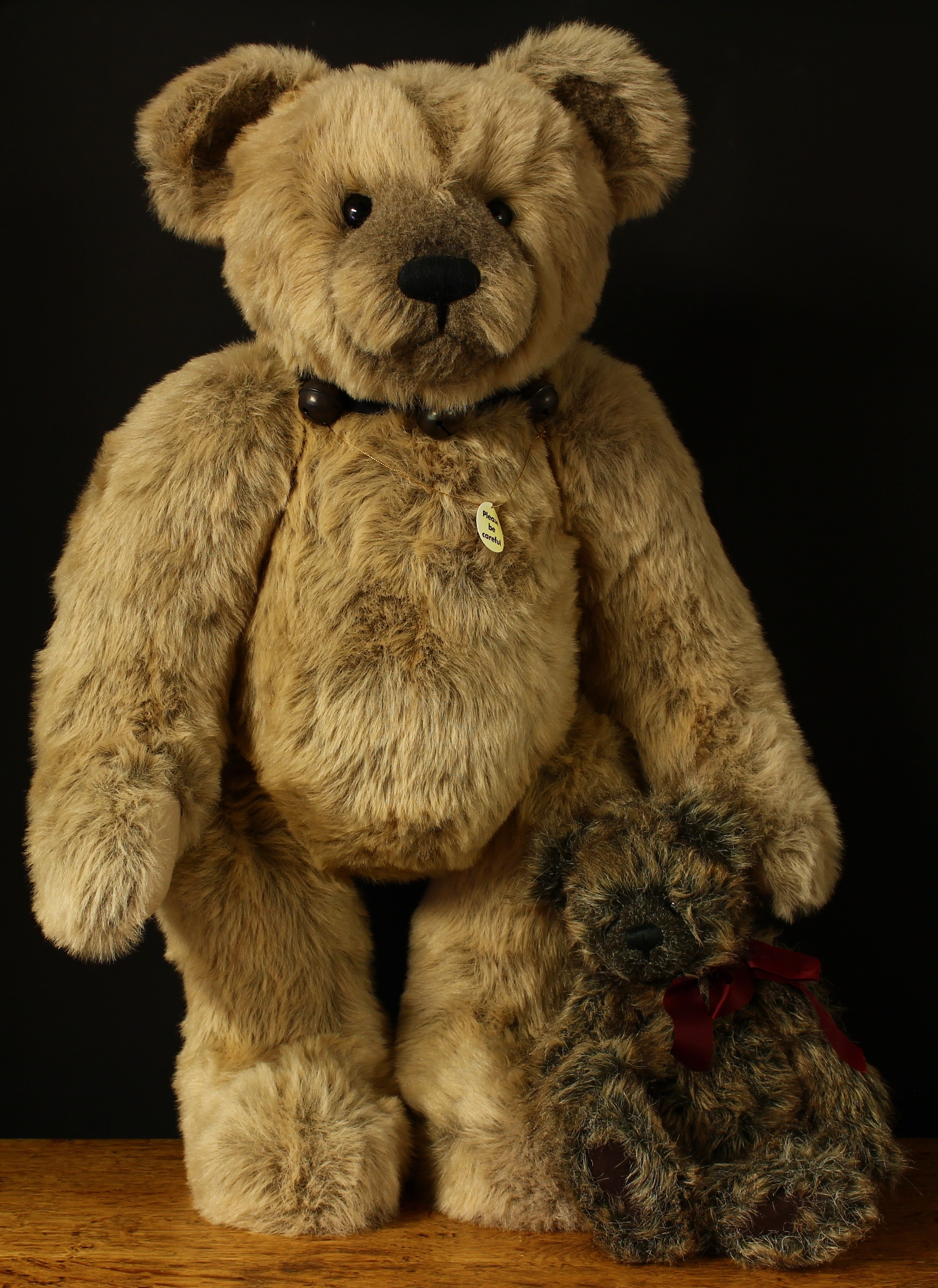A large Charlie Bears teddy bear with ribbon collar and bells around neck, 76cm high; another smaller Charlie Bears teddy bear, 40cm high (2)