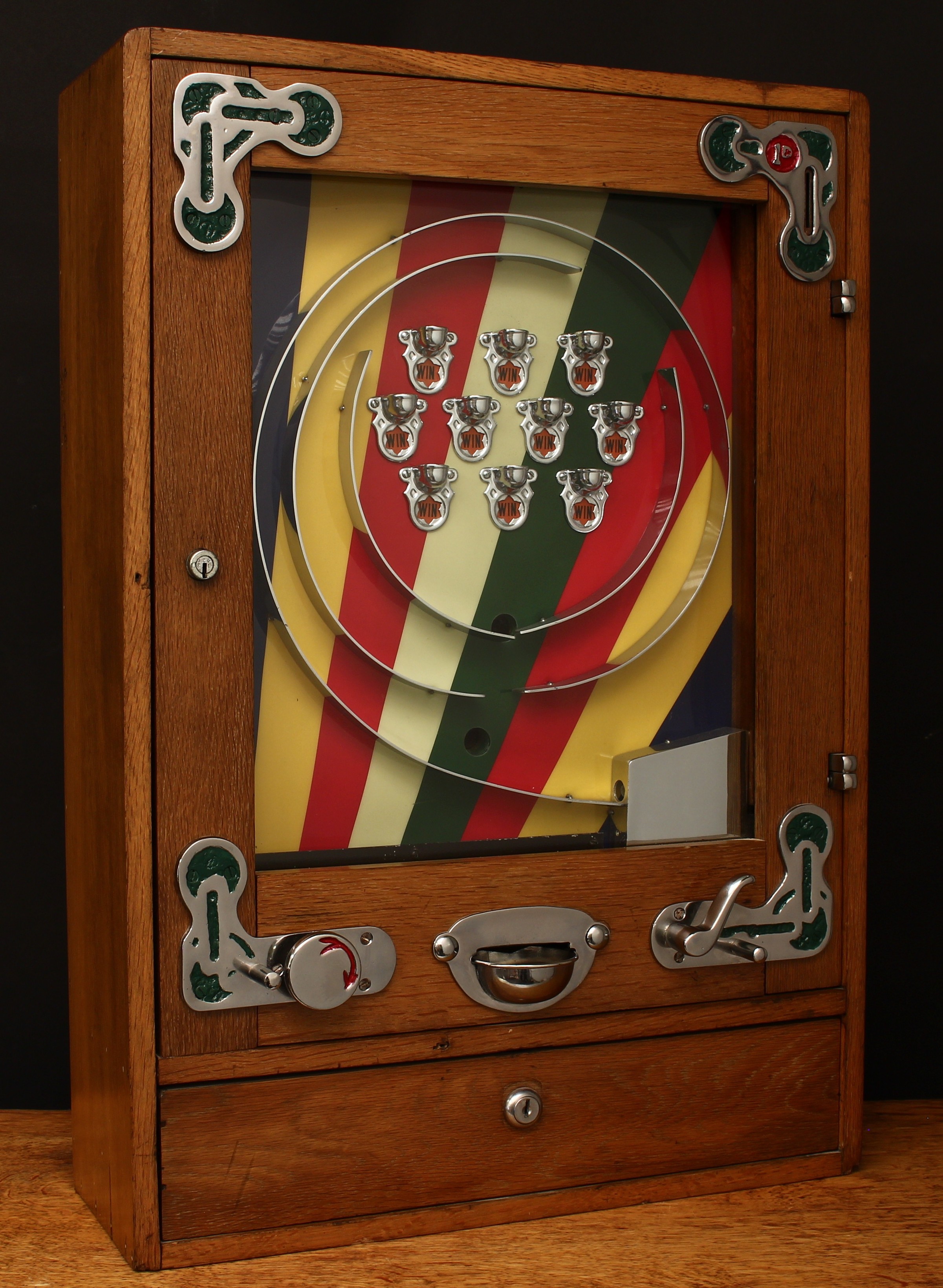A 1950's Bryans (Bryans Works, Kegworth, Derby) 'Allwins' mechanical penny slot arcade/amusement machine with manual payout, rounded rectangular shaped oak case, the inner multicoloured back plate with ten cups, curved trigger, glazed hinged door, the top of the case stamped '3426', 64cm high, 44cm wide, 15cm deep