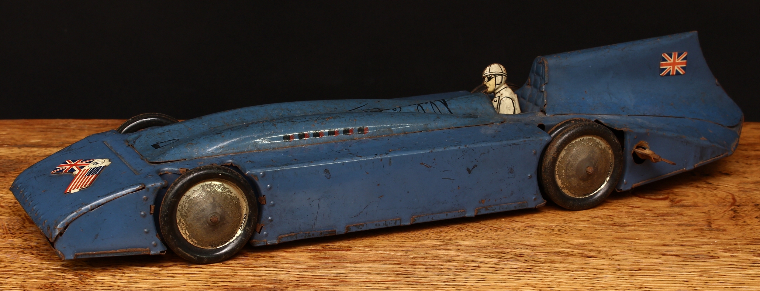 British Motoring Interest - a Betal tinplate and fixed keywind/clockwork model of Sir Malcolm Campbell's 'Blue Bird' Land Speed Record car, blue body with lithographed detail including Union Jacks and the U.S. flag, facsimile Malcolm Campbell signature, pressed tinplate and lithographed driver figure, twin rear wheels, 42cm long, unboxed