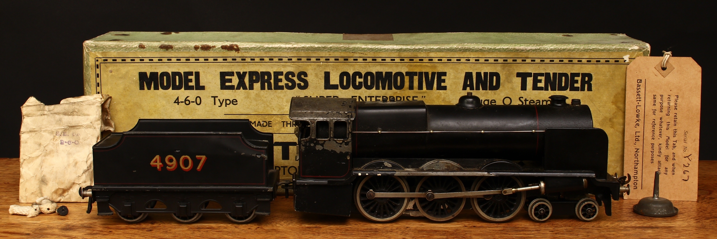 A Bassett-Lowke O Gauge tinplate and live steam 4-6-0 'Super Enterprise' locomotive and six wheel tender, model 6655/0, black livery, No.4907, boxed with original inner corrugated packaging pieces, cardboard guarantee tag, various accessories and original acknowledgement of order form, dated 10th December 1948; a Bassett-Lowke right hand point, boxed etc
