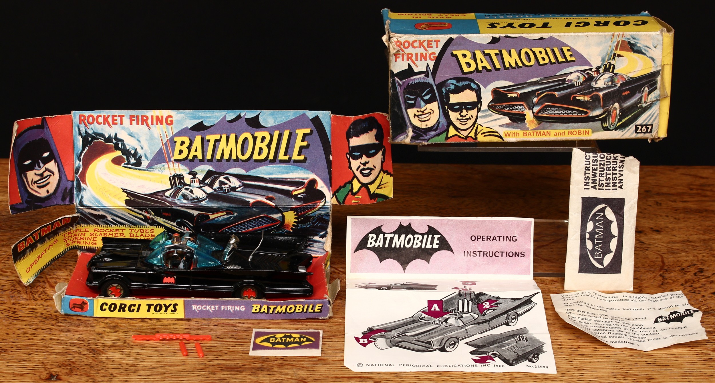 Corgi Toys 267 Rocket Firing Batmobile, black body with black and red Bat decals to side doors, seated plastic figures of Batman and Robin to red interior, gold cast hubs with red Bat logo to centres, plastic aerial intact, boxed with original inner cardboard pictorial display stand, remnants of instructions packet, remnants of literature sheet, two detached red plastic rockets and sprue, operating instructions and lapel/shirt self-adhesive badge on backing sheet