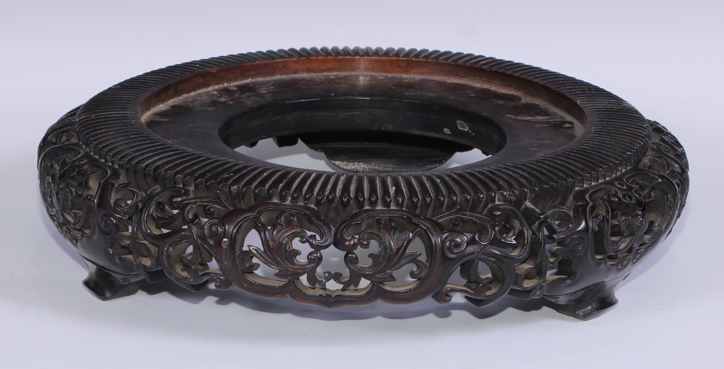 A large Chinese carved and pierced hardwood vase stand, 35cm diameter, early 20th century