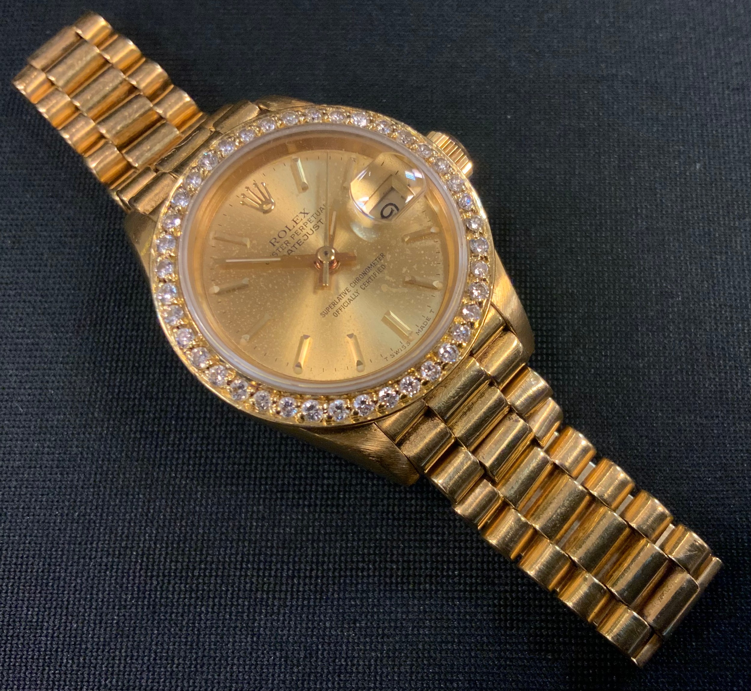 A ladies Rolex Datejust Oyster Perpetual Superlative Chronometer 18ct gold bracelet wristwatch, signed gilt dial, date aperture, diamond encrusted bezel, integral bracelet, 8570F, 750 18k import marks, 71.8g gross