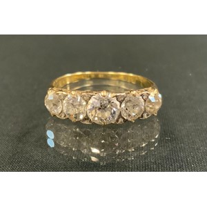 An Edwardian old cut diamond ring, linear set with five graduated diamonds, total estimated diamond weight approx 1.5ct, unmarked gold coloured metal shank, size S, 3.4g gross