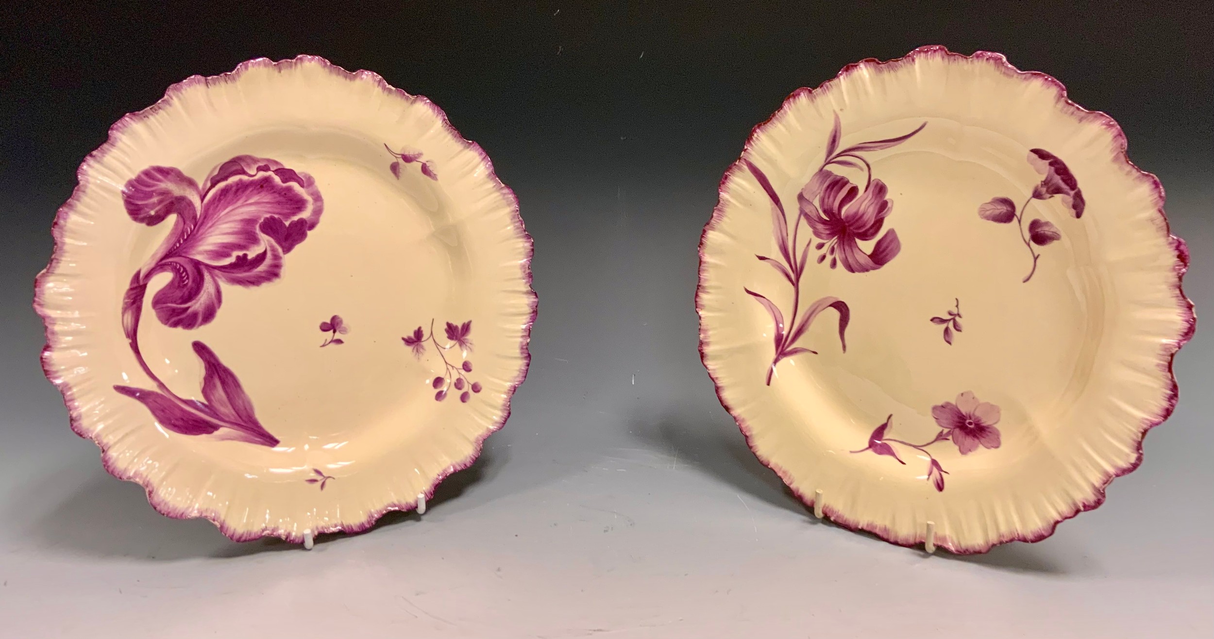 A pair of early 19th century creamware plates, painted in puce with stylised flowers, undulating feathered borders, 22cm diam, c.1820 Dean and Mary Rockwell Collection label
