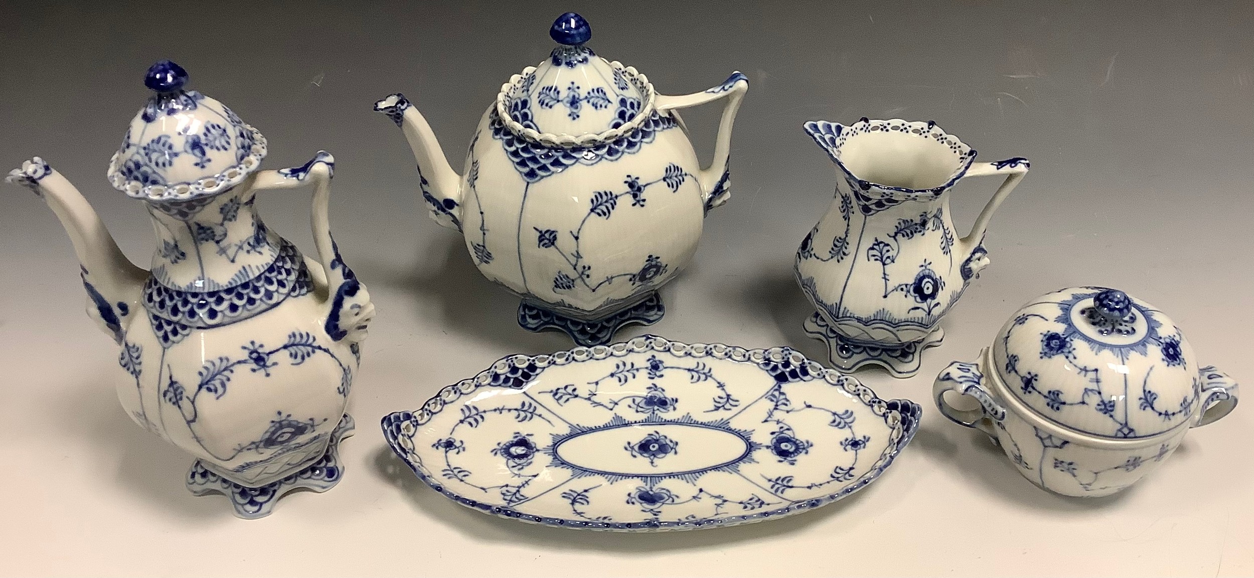 Royal Copenhagen tea ware - comprising ribbed hexagonal teapot and cover, coffee pot and cover, milk jug, sucrier and cover, oval dish, each decorated in underglaze blue with stylised flowerheads and scrolls, the coffee pot 21cm high, printed marks, 1030, 1118, 11401128, 1115 (5)
