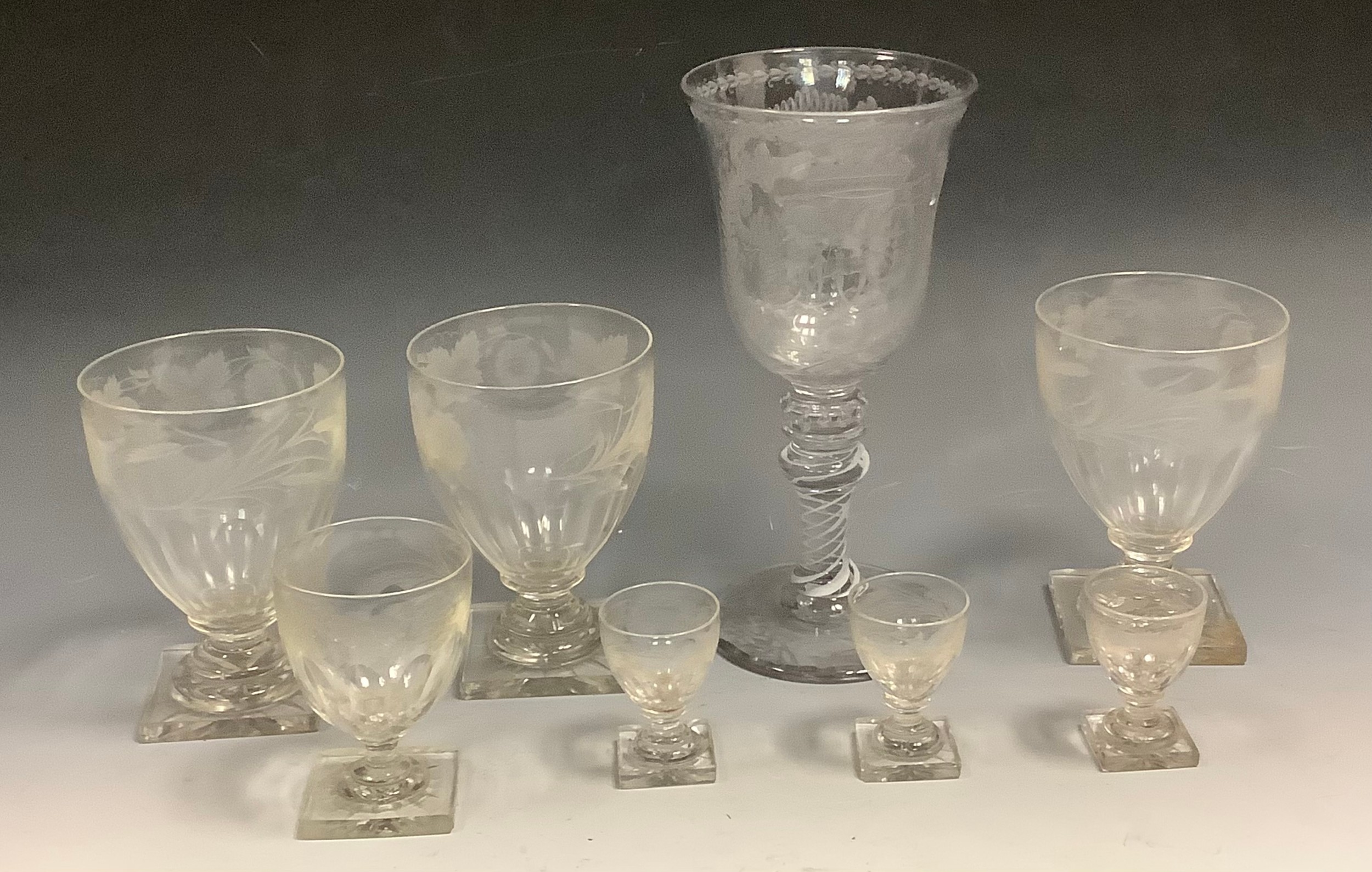 A Freemason clear glass goblet, the bell shaped bowl engraved with shaking hands and heart within scrolls, knopped spiralled band to stem, 24cm high;  three rummers, engraved with barley ears and vine, lemon squeezer bases, 14cm high;  others, smaller