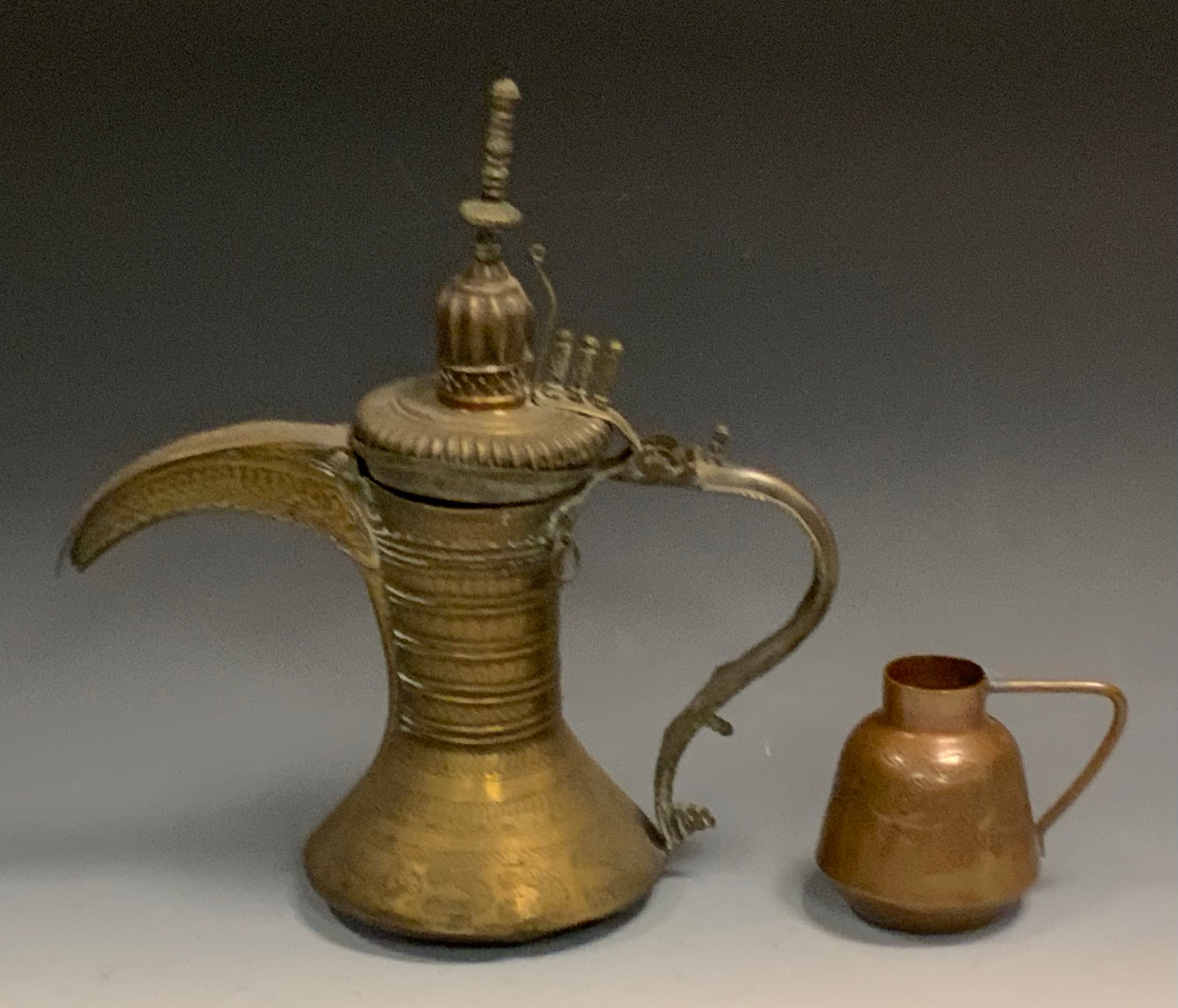 A Persian coffee pot, of usual design, 32cm high;  a copper jug, pin hammered decoration, 9.5cm high (2)