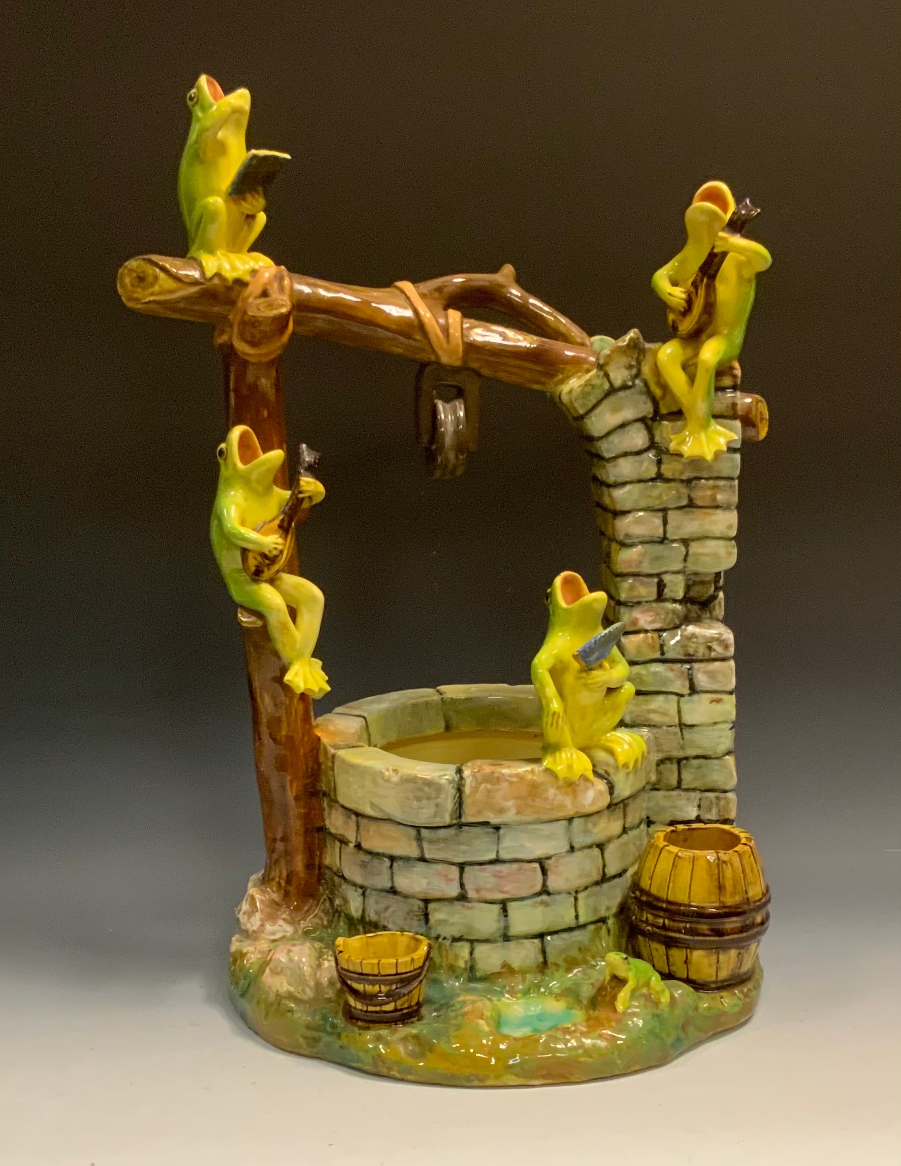 A Jérôme Massier majolica comical group, modelled with four frogs singing and playing instruments on a wishing well,  50cm high, 30cm wide,  painted JMF Vallauris mark, c.1890
