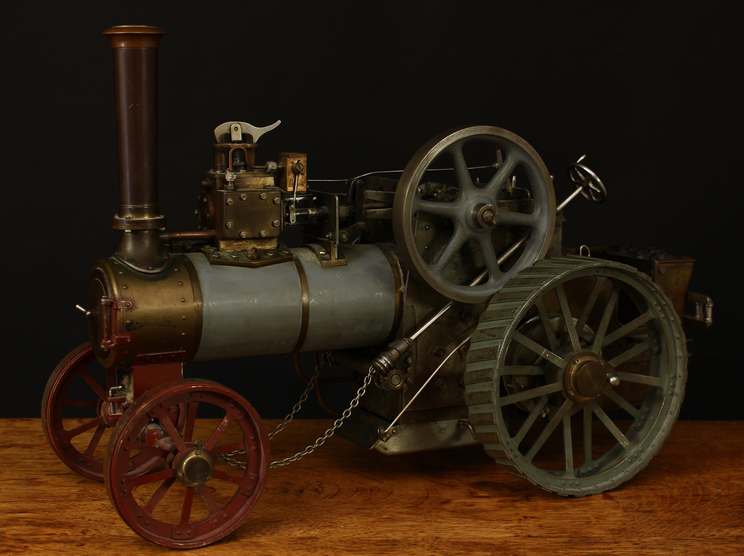 A scratch-built live steam traction engine, unknown maker, flat grey livery, fitted with English style brass straked wheels, 4.5" diameter open cast flywheel, single chimney, 46cm long