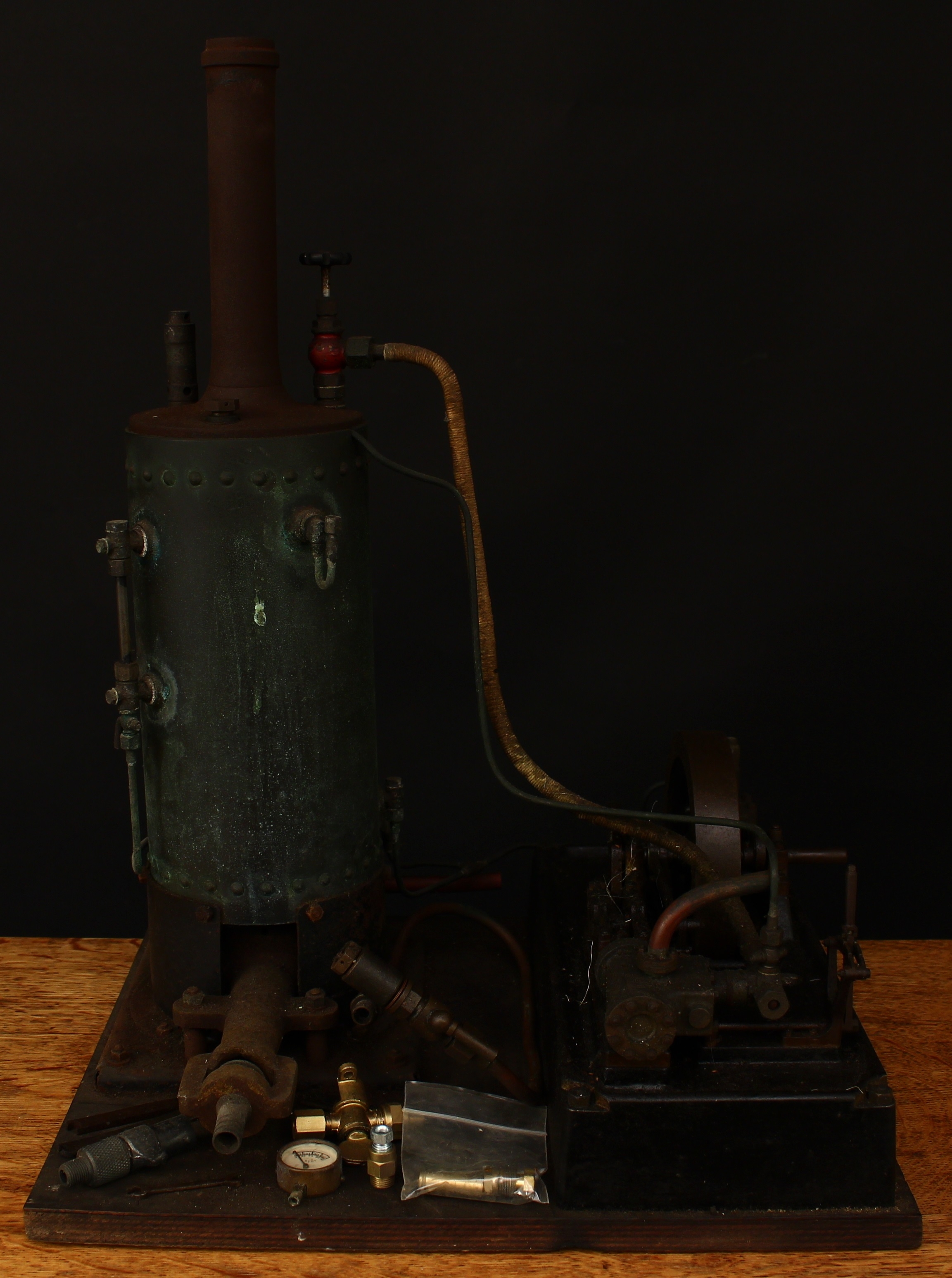 A mid-20th century partially scratch built model of a donkey engine, gas fitting, fitted with a 5" single flywheel, displayed on a rectangular wooden base, 46cm high, reputedly built by Frank Gordon of Rolls Royce, Derby between 1945 and 1954