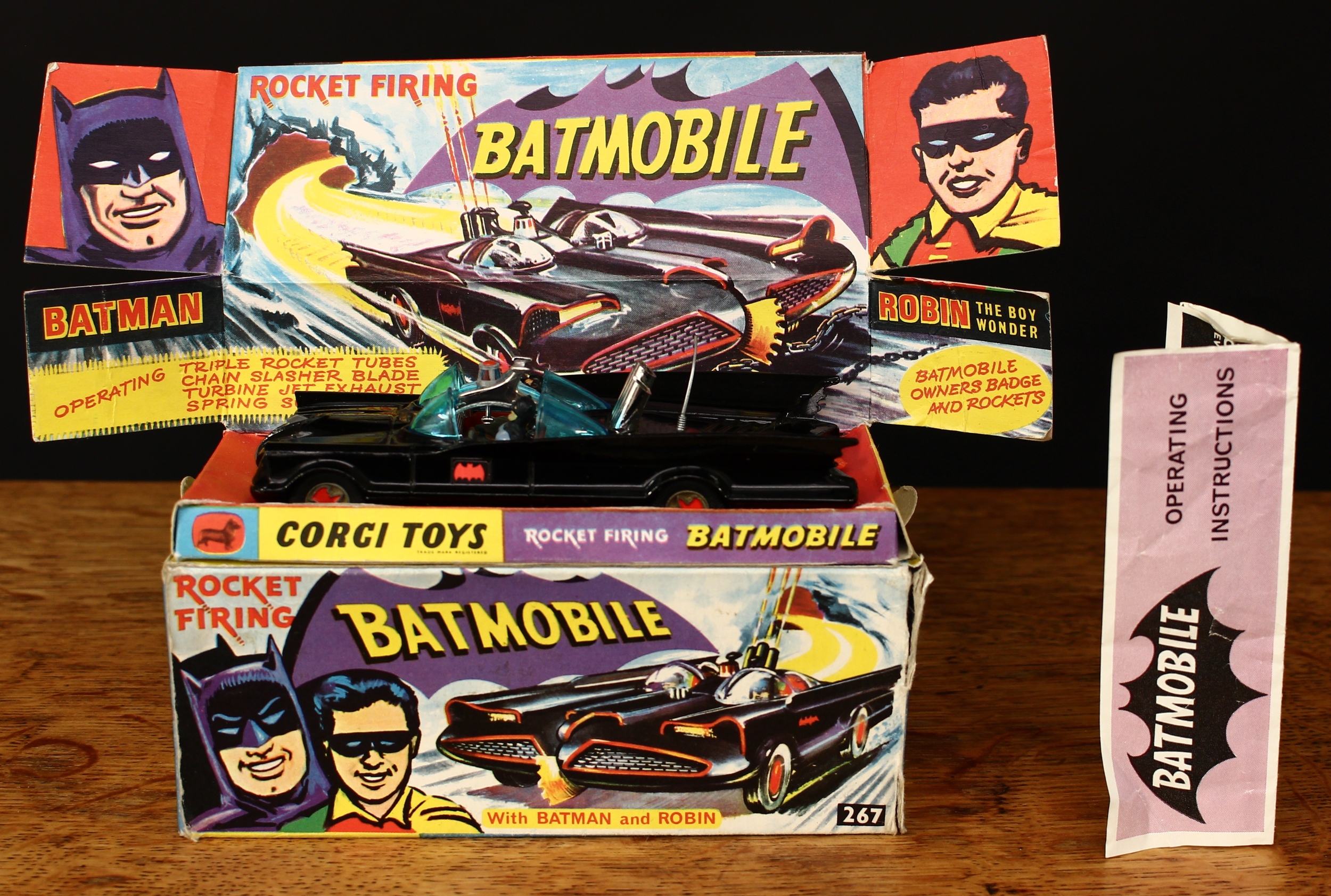 Corgi Toys 267 Rocket Firing Batmobile, black body with black and red Bat decals to side doors, seated plastic figure of Batman and Robin to red interior, gold cast hubs with red Bat logo to centre, plastic aerial intact, boxed with original inner pictorial display stand and 'operating instructions' literature slip