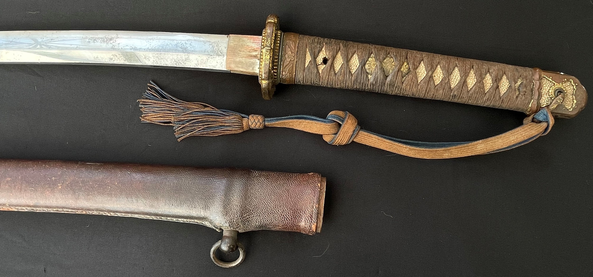 WW2 Imperial Japanese Officers Shin Gunto Katana Sword. Single edged 660mm long blade. Tang is signed Noshu ju Takeyama Yoshinao Kin Saku . Overall length mm. Complete with Company Grade Officers Knot and leather covered active service scabbard. War Souvenir of British Lt. Col Charles Frederick Seston MBE, RIASC.