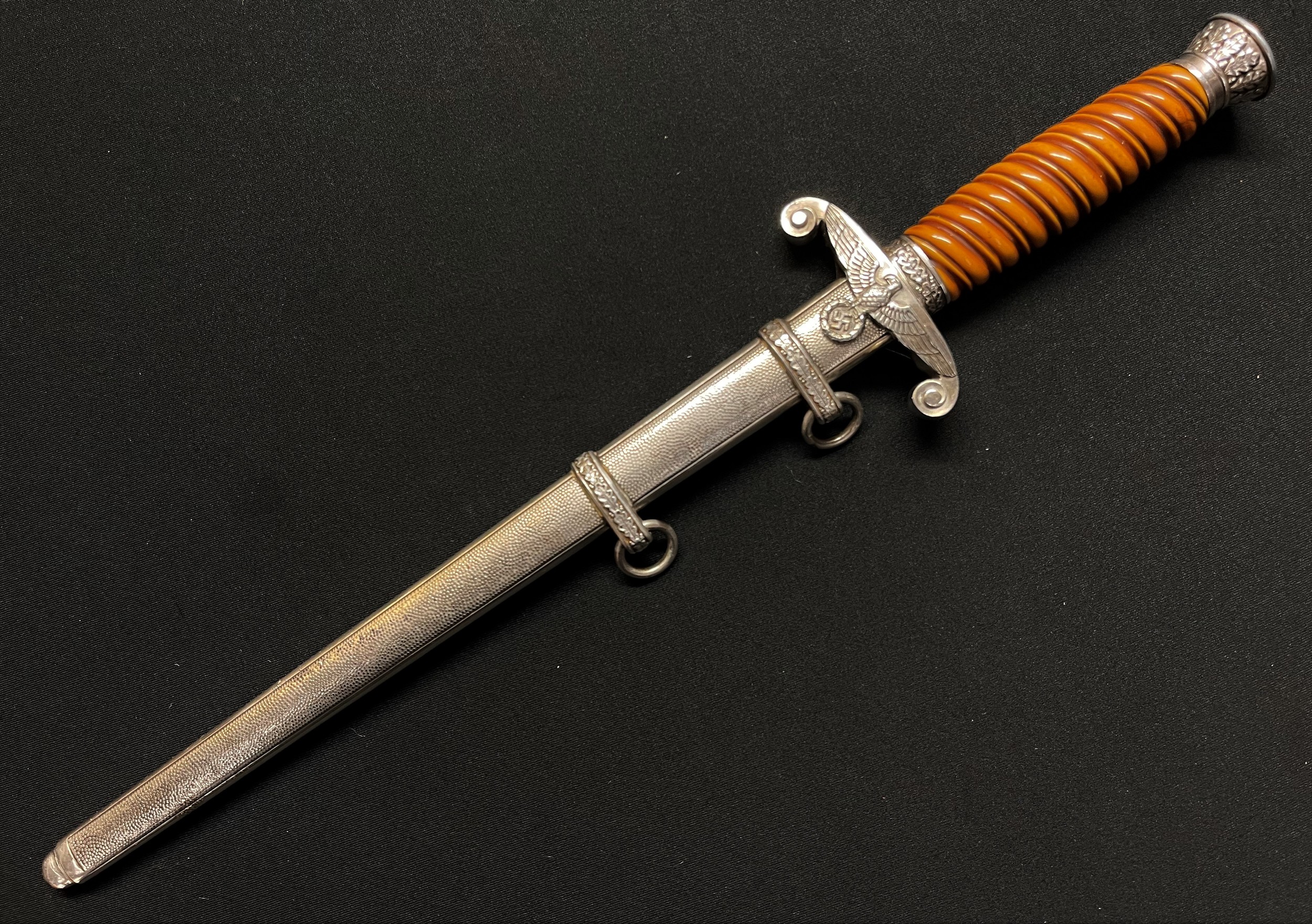 WW2 Third Reich Heer Offizierdolch Army Officers Dagger with double edged blade 250mm in length maker marked "Original Eickhorn, Solingen". Early heavy plated fittings. Orange grip. Overall length 375mm. Complete with original scabbard again with early plated fittings.