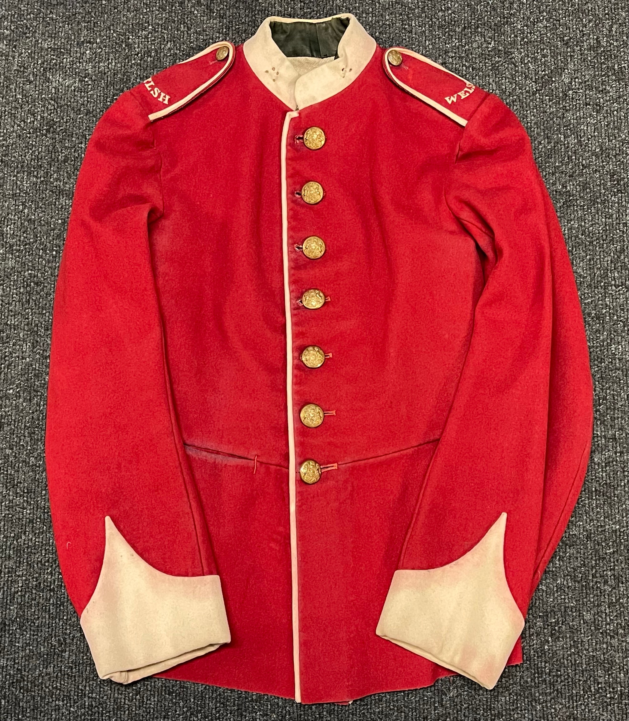 Edwardian Welsh Regiment Red Dress Tunic. Kings Crown General Service pattern Buttons which are original to the tunic. Embroidered shoulder titles. No label. WD Inspection Stamp inside sleeve with D code letter. Small size approx. 28 inch chest. 1902-1905.