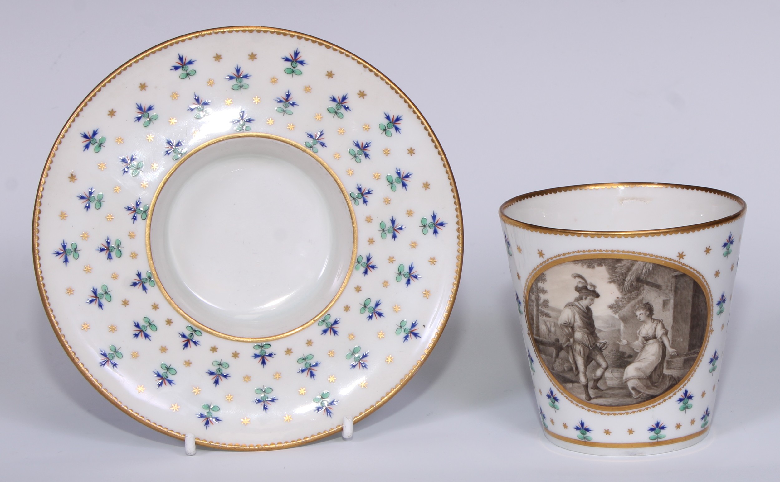 A Derby trembleuse cup and saucer, decorated with a gilt  oval cartouche  en grisaille with Gualtheus & Griselda, the ground with  polychrome sprigs interspersed with gilt stars, gilt dentil border, entwined handle, 15.5cm diam, the cup titled, crown and D mark in blue, the saucer in puce, c.1790