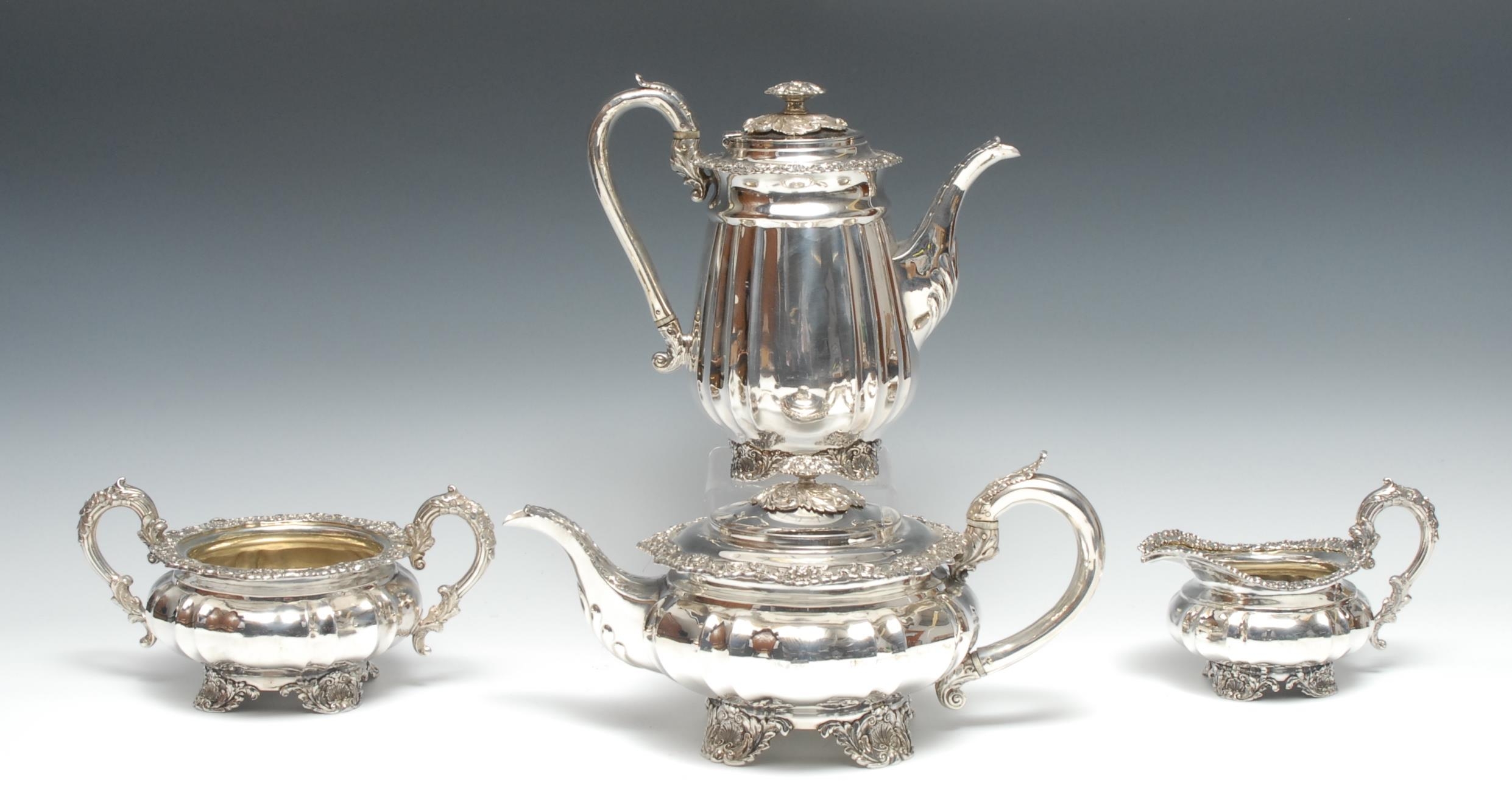 A George IV Rococo Revival silver four piece fluted tea and coffee service, comprising melon shaped teapot, coffee pot, milk jug and sugar basin, acanthus boss finials, flower and foliate borders and scroll handles, the coffee pot 22cm high, Joseph Angell I, London 1826, 2340g gross