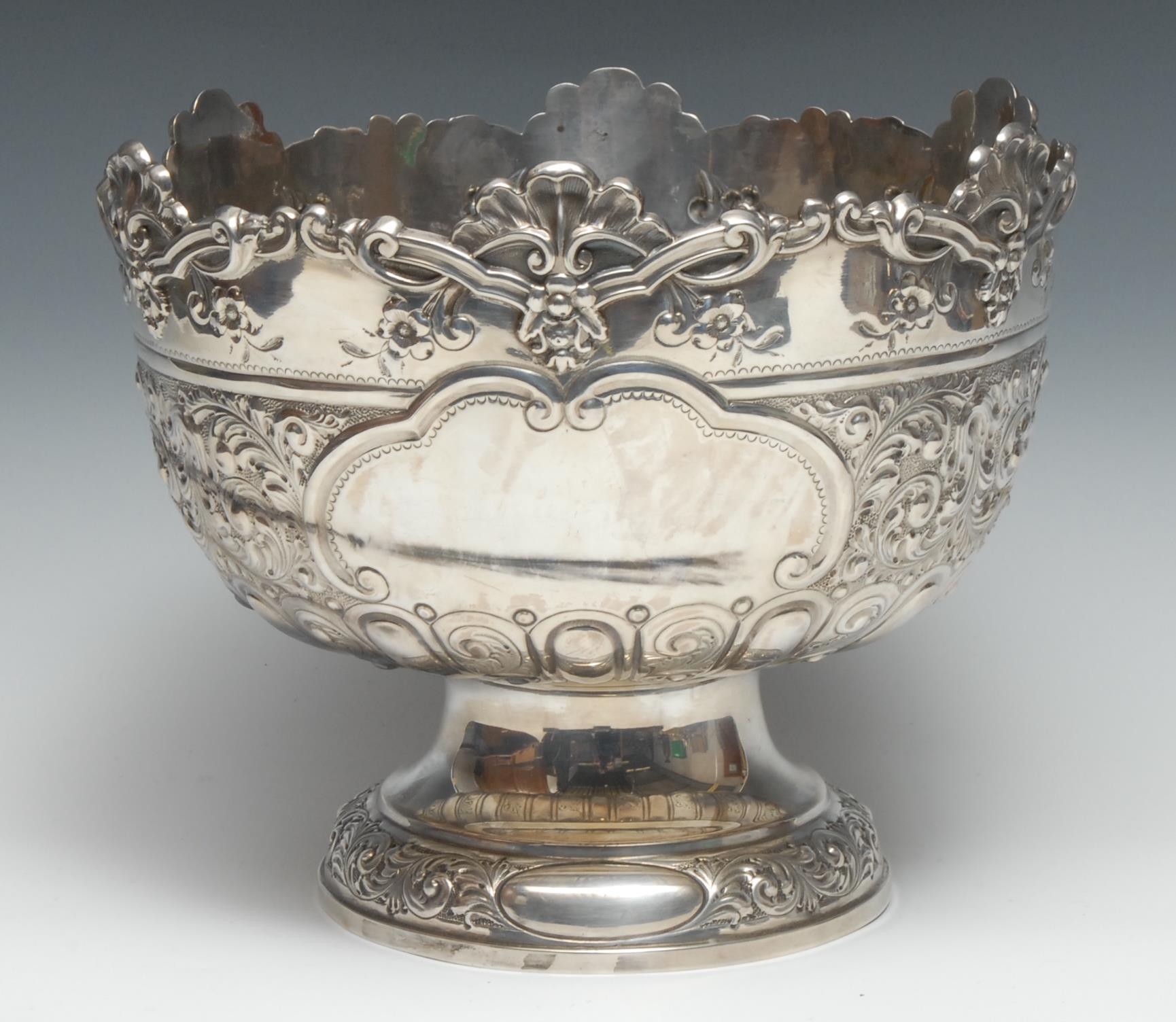 An Edwardian silver pedestal punch bowl, half-fluted and chased with flowers and scrolling foliage on a matted ground, 28cm diam, Hammond, Creake & Co, Sheffield 1902, 1272g