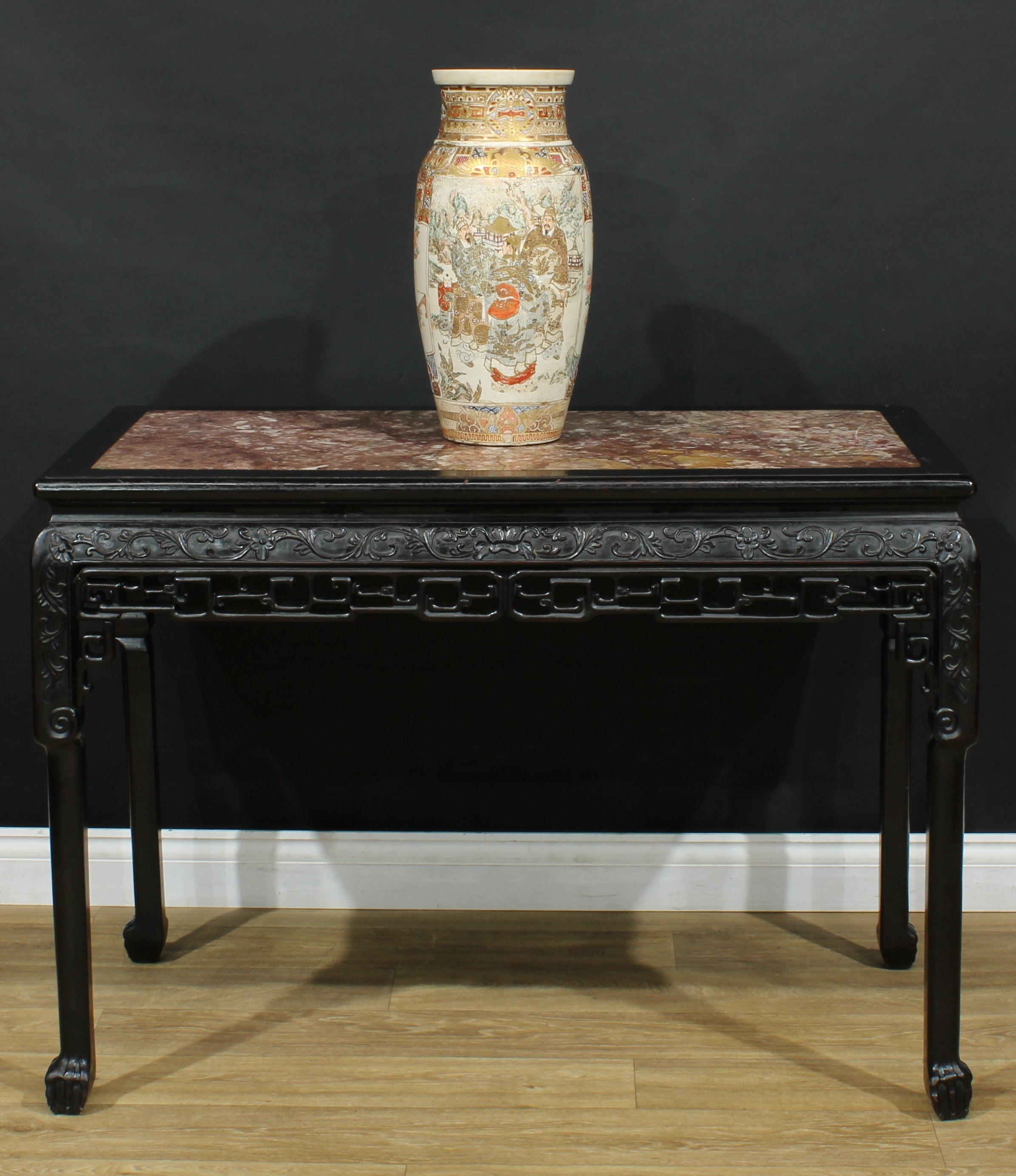 A Chinese hardwood centre table, rectangular top with moulded edge and inset hardstone panel, the frieze carved with flowering leafy stems, above a shaped apron pierced and carved with clouds, straight legs, ball and claw feet, 80.5cm high, 112.5cm wide, 59.5cm deep