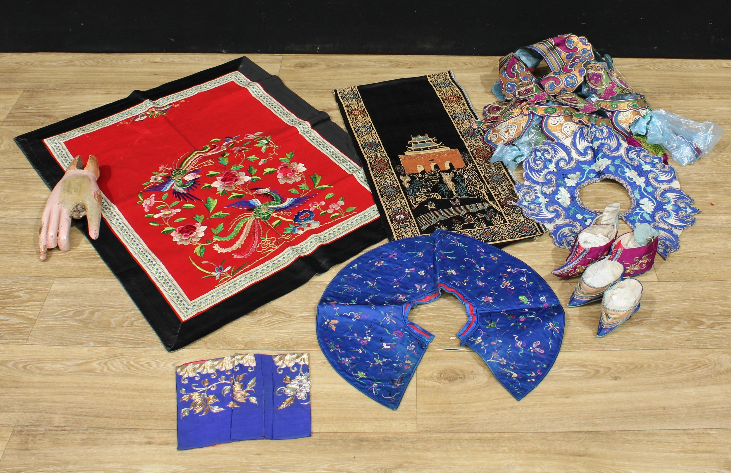 A pair of Chinese silk lotus shoes, embroidered and worked in coloured threads on a blue ground, 11cm long, first-half 20th century; another pair, similar, slightly larger, 16cm long, c. 1900; various Chinese textile embroideries and garments, including cuffs, collars, etc; a 19th century Oriental softwood carved hand, possibly from an idol, 28cm long, [collection]