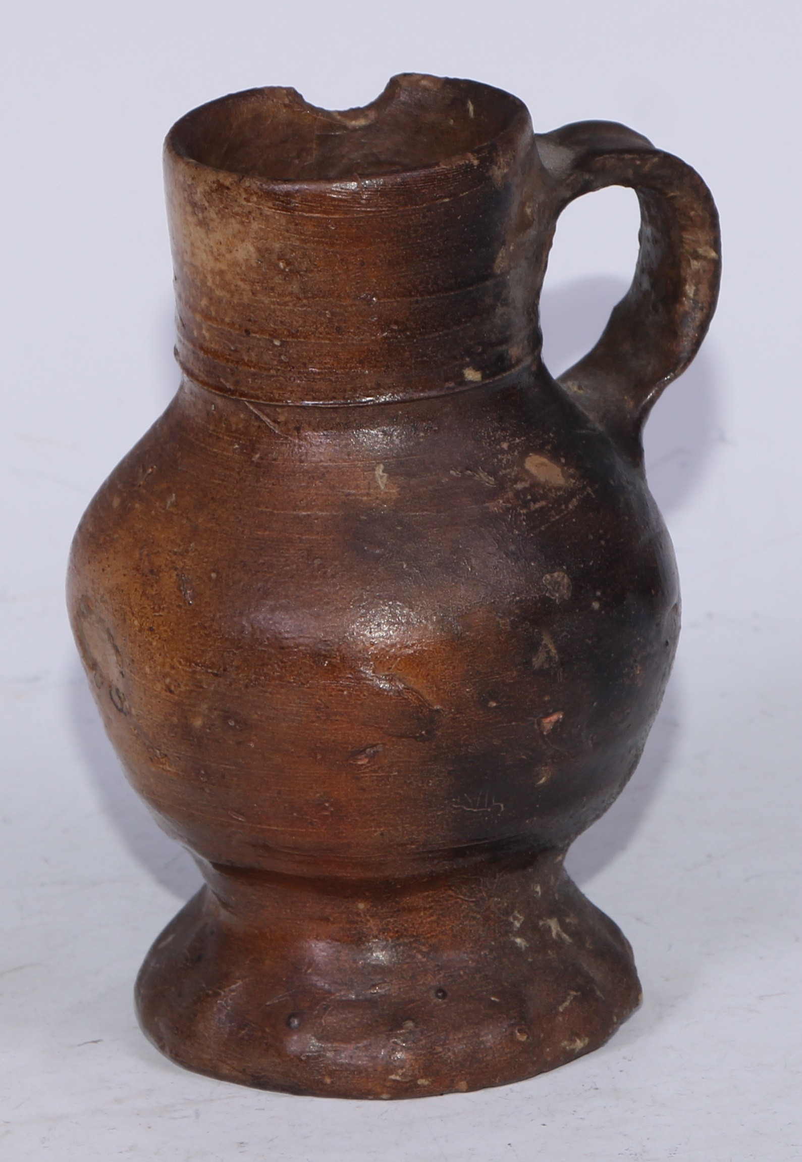 A Medieval pottery drinking jug, loop handle, pinched base, 14.5cm high, c.13th/14th century