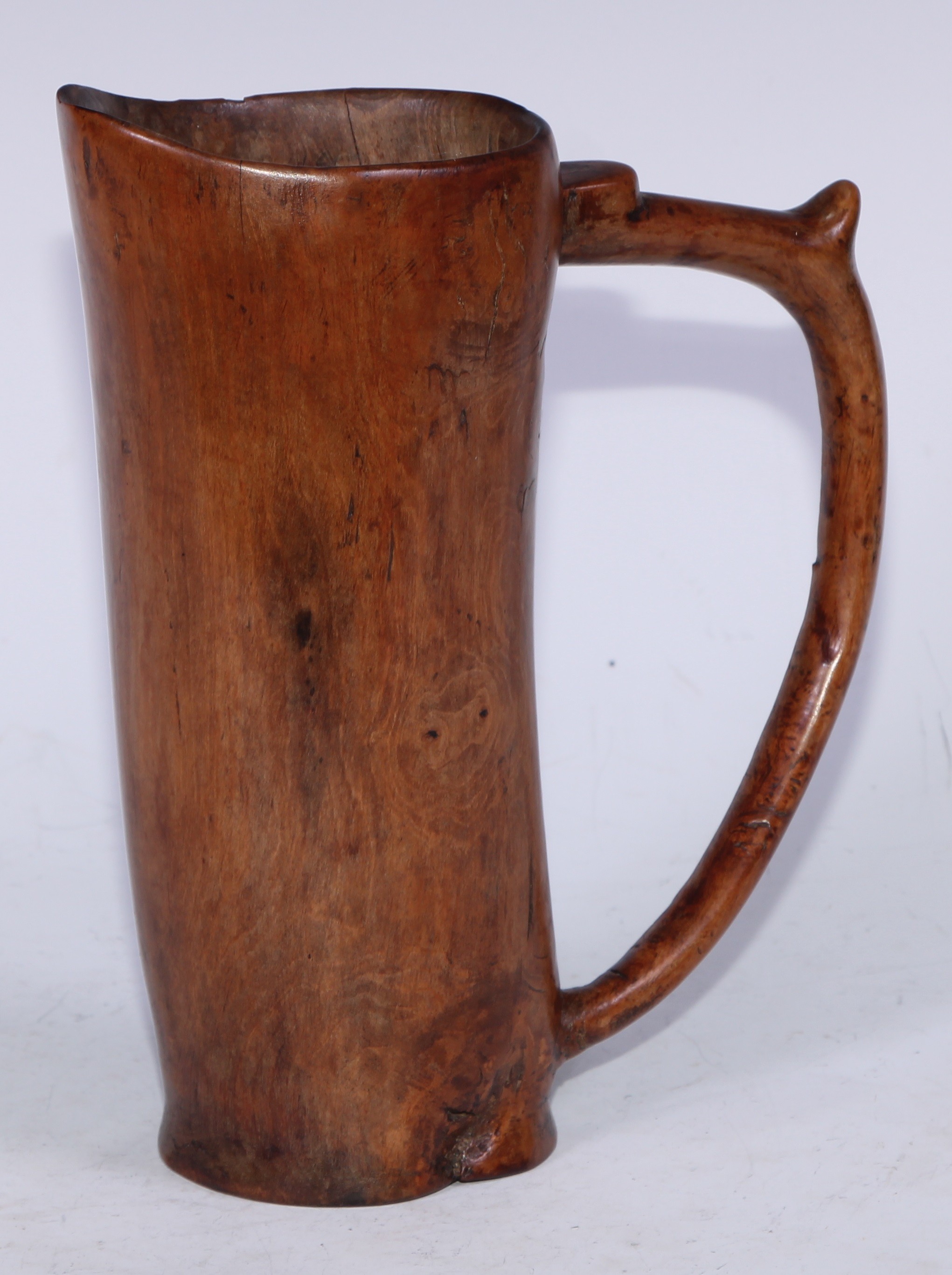 Treen - a 19th century dug out drinking vessel, integral scroll-capped handle, 20.5cm high