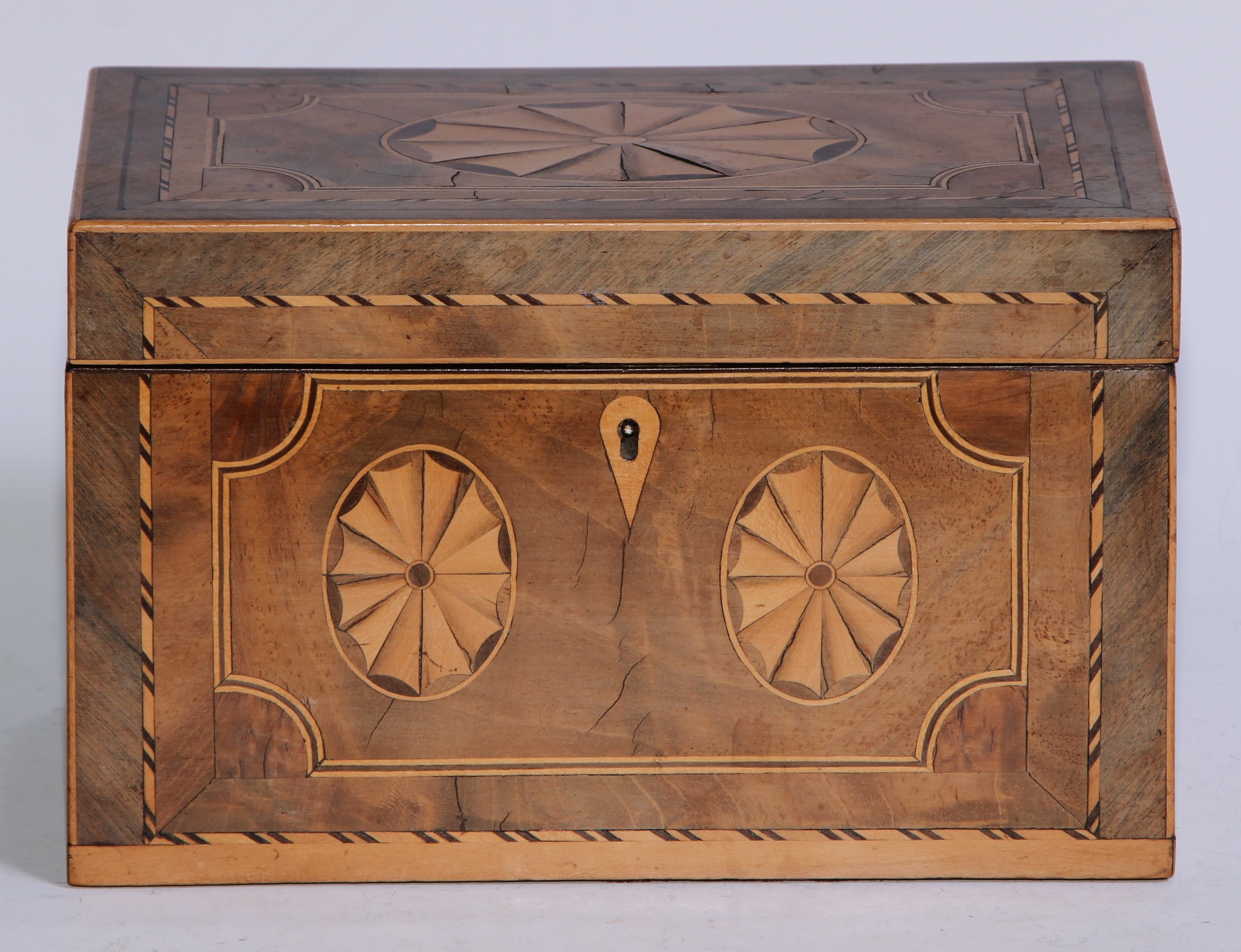 A George III mahogany and marquetry rectangular tea caddy, inlaid with oval batwing paterae, hinged cover enclosing a pair of lidded compartments, outlined throughout with barberpole stringing, 19.5cm wide