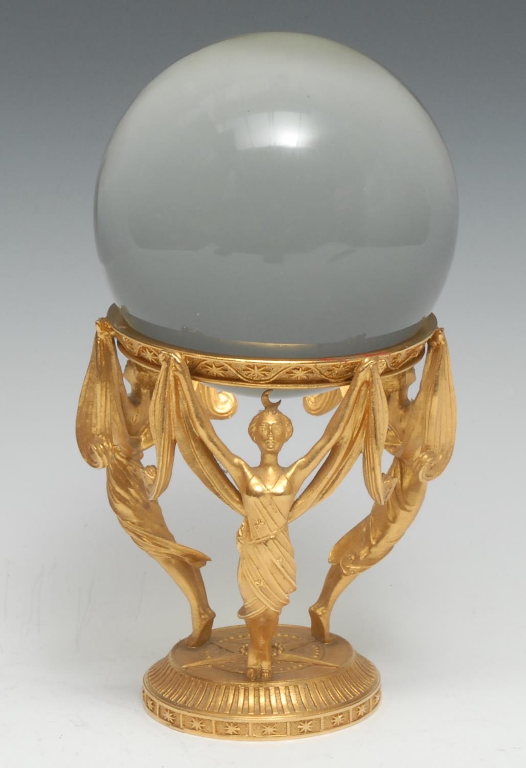 Mysticism and the Occult - a crystal ball, the gilt metal stand cast with scantily clad female figures, 20cm high