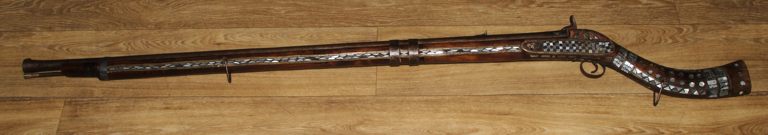 A Middle Eastern percussion jezail, 11.5cm barrel, East India Company lock, the stock applied with brass and profusely inlaid with mother of pearl, steel ramrod, 147cm long, Afghanistan, 19th century