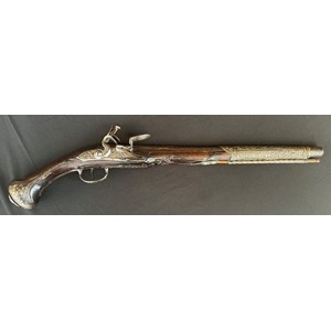 Flintlock Pistol with 360mm long barrel. Bore approx. 15mm. Overall length 548mm. Action will only hold at the half cocked position. Heavily decorated overall with cast brass and silver inlays. Complete with ramrod. No makers marks. Section 58 (2) no licence required.