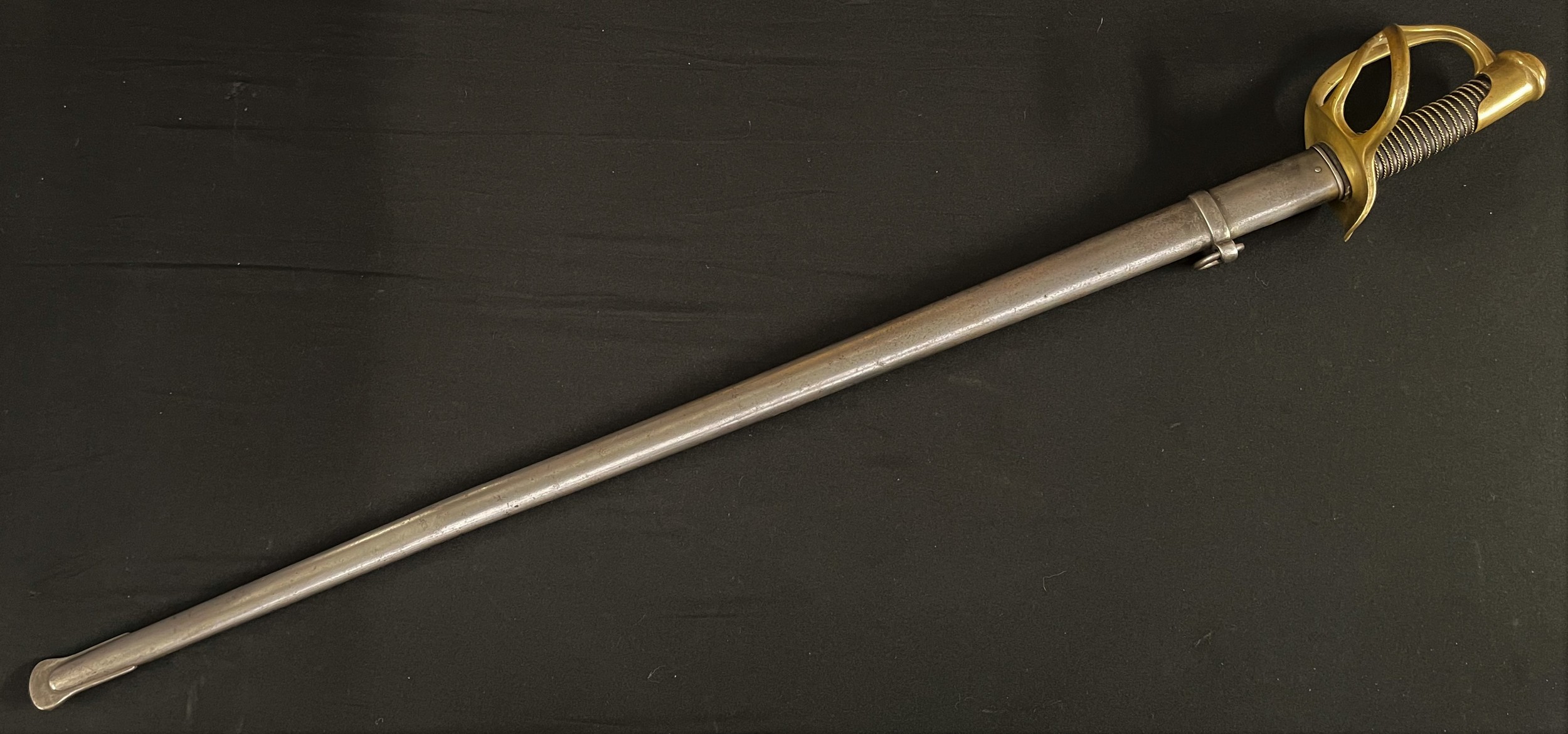 19th Century French Dragoon Sword M1854/1882 with double fullered, single edged blade 915mm in length. Maker marked to spine of blade and dated. Wire bound leather grip. Brass guard stamped "21633". Overall length 107.5cm. Complete with steel scabbard with single suspension ring. Matching serial number "21633". Inspection stamped.