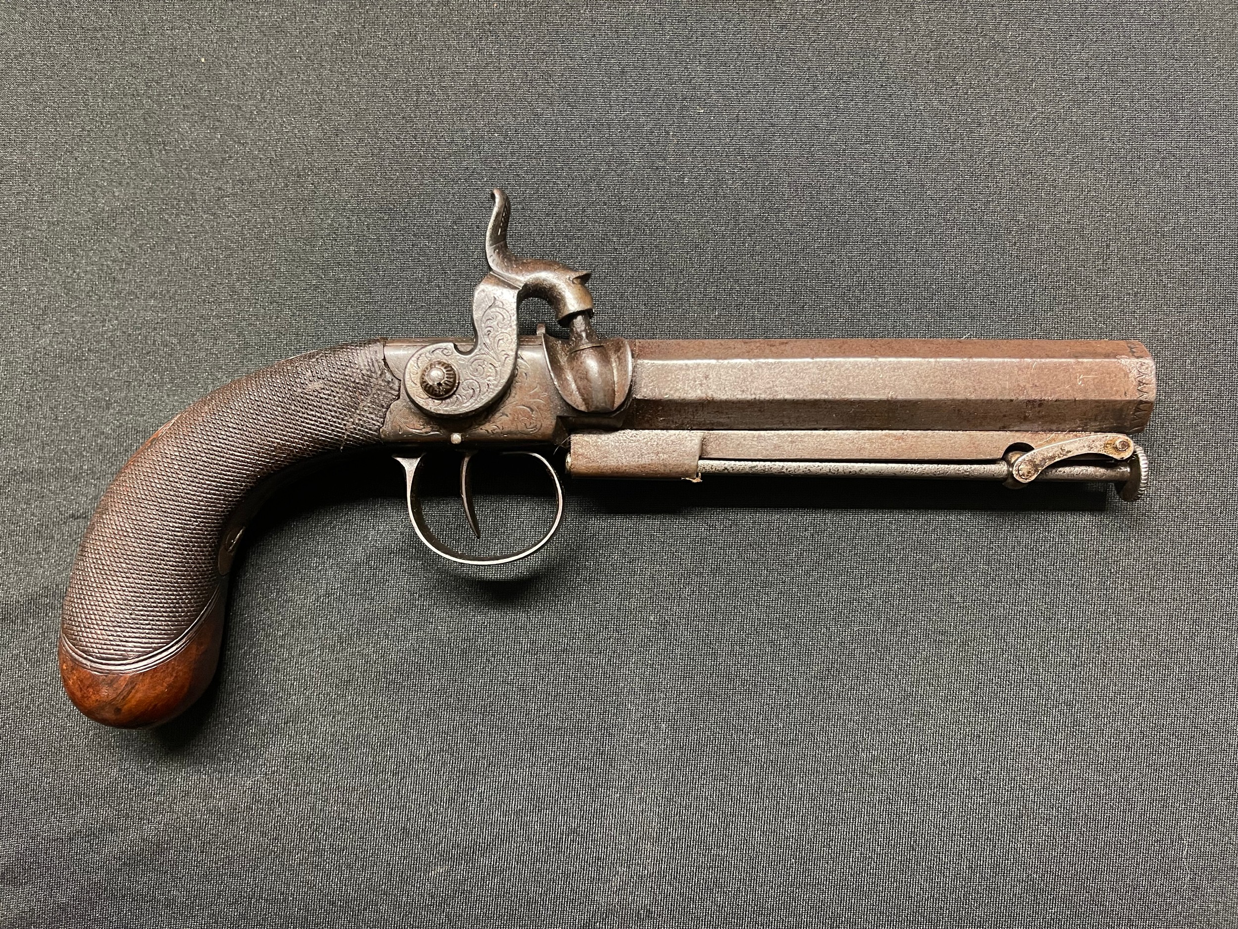 Percussion cap pistol with 115mm long barrel. Bore approx. 14mm. Proof marked. Barrel signed "Parkes, London". Working action which holds at both full and half cocked positions. Folding integral ramrod. Chequered wooden butt with inset blank silver escutcheon plate.  Overall length 225mm. Section 58 (2) no licence required.