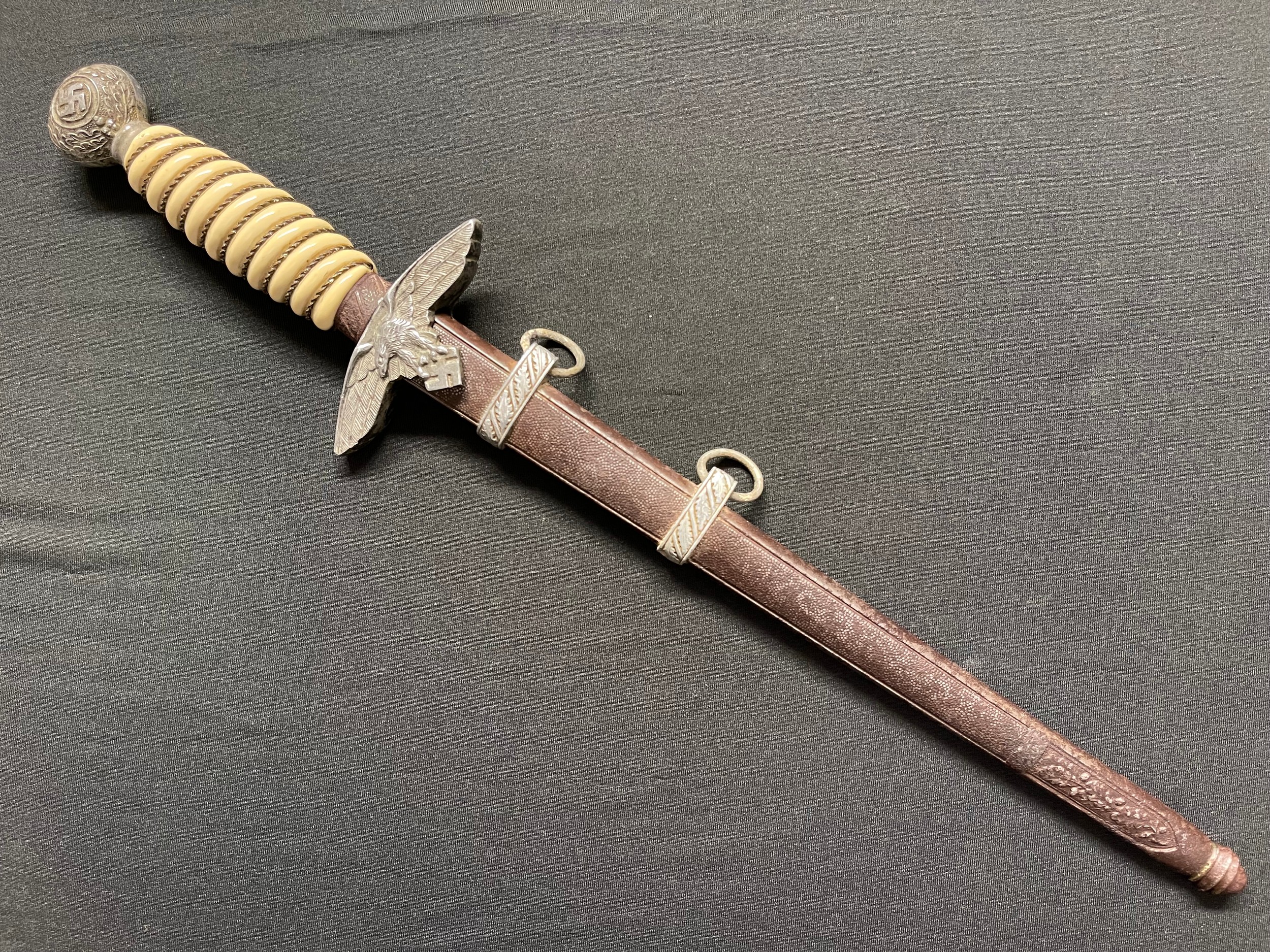 WW2 Third Reich Luftwaffe Dagger with double edged blade 260mm in length maker marked "Alcoso, Solingen". White grip with grip wire present. Overall length 395. Complete with steel scabbard with alloy fittings.