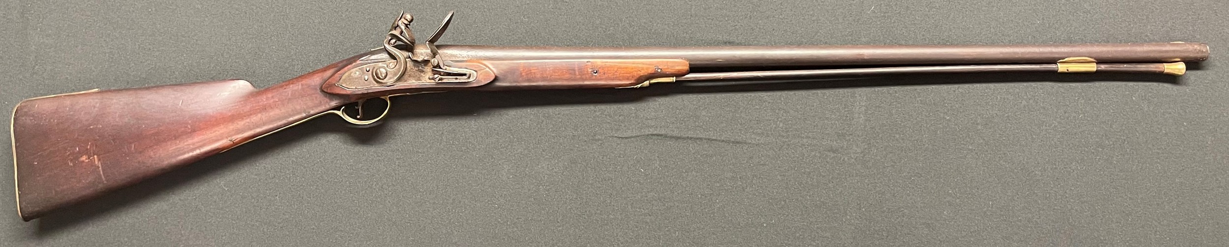 Flintlock Musket with 800mm long barrel. Bore approx. 17mm. Working order. Lock will hold at both full and half cocked positions.  Brass  trigger guard. No makers mark. Brass butt plate. Complete with brass tip ramrod. Overall length 1200mm. Section 58 (2) no licence required.